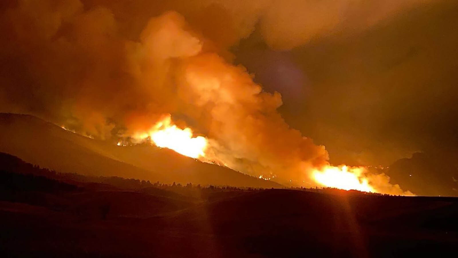 Firefighting crews worked overnight Thursday on back burning operations to battle the Elk Fire in northern Wyoming. Some of those including drones dropping incendiary devices in hard-to-get-to places and created an eerie glow in spots overnight.