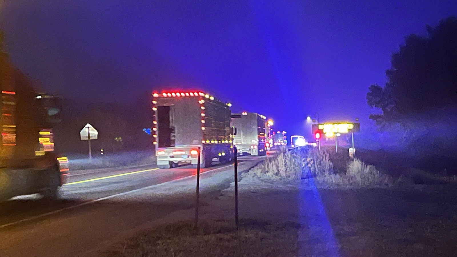 A convoy of trucks move into the Elk Fire zone to help move cattle off the mountain.