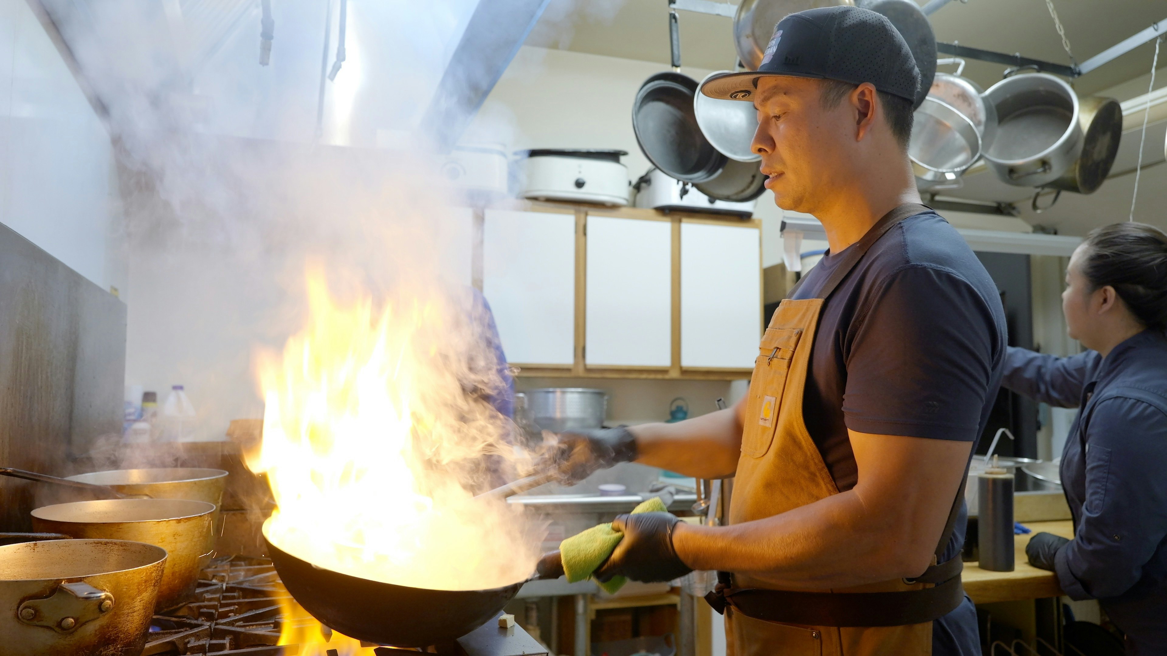 V Cafe Owner Elvis Nguyen maneuvers the wok on June 21, 2025.