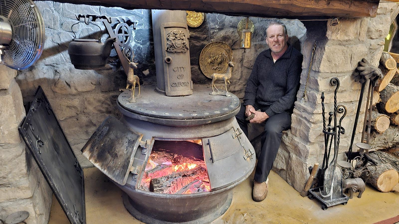 Cyning Meadowcroft sits inside the sandstone nook he built around his pot-bellied stove. The sandstone draws moisture away, making it an ideal place to warm up.