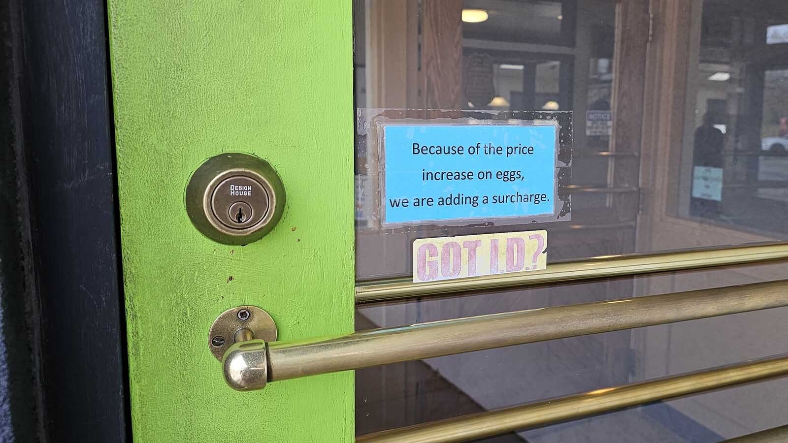 A sign on the door at Epic Egg in Cheyenne advises customers that the restaurant has added a surcharge to its egg dishes of 8%.