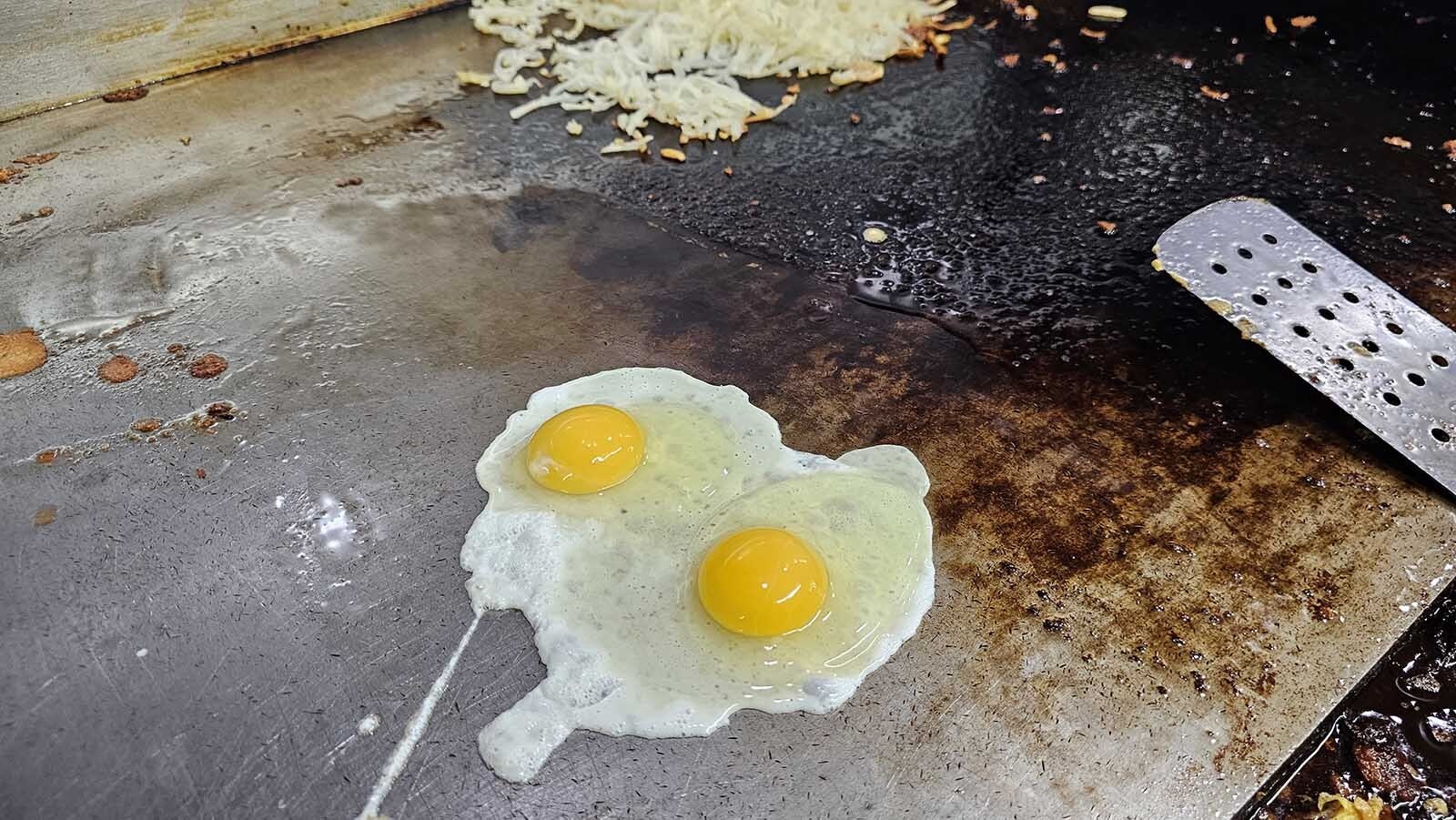 Eggs are getting to be like gold lately — always going up in price. Two eggs slowly cook on the grill at the Diamond Horshoe Cafe in Cheyenne, which is among restaurants who have had to raise menu prices due to the cost of the breakfast favorite.