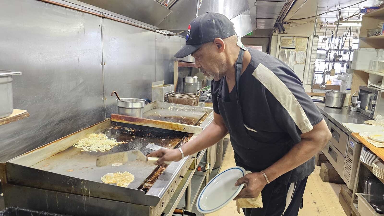 Willie Banks flips a set of over-easy eggs on the grill at Diamond Horseshoe Cafe in Cheyenne.