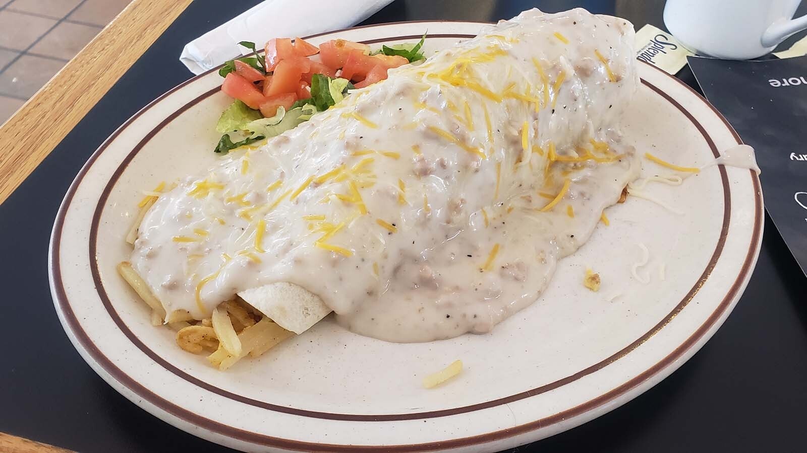 A breakfast burrito smothered in gravy makes for a hearty meal.