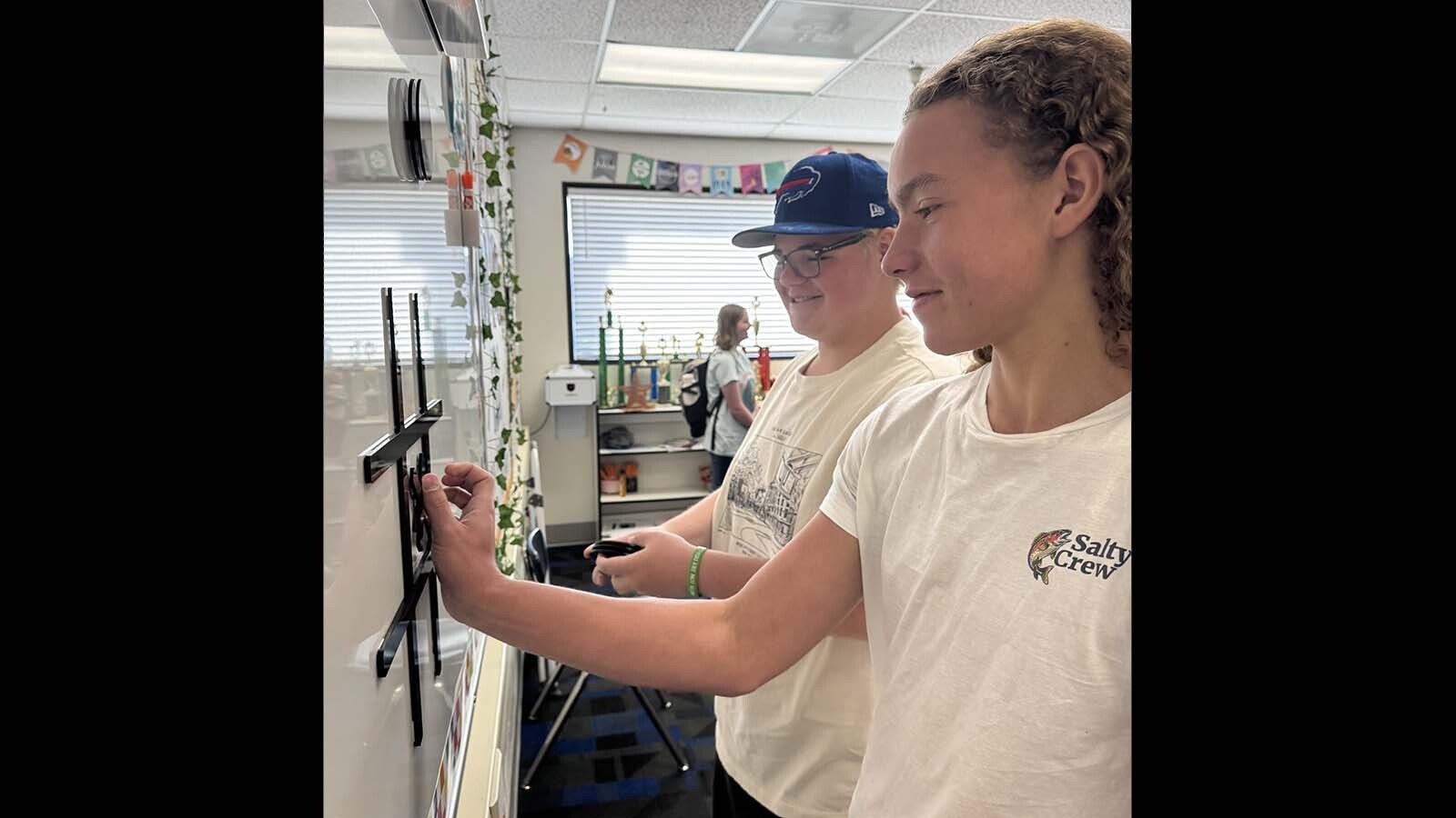 Evanston High School sophomores Seth Morrow, left, and Jayden Mills teach themselves how to play live-action tic-tac-toe while silently wishing they had their phones back during a recent day at Evanston High School.