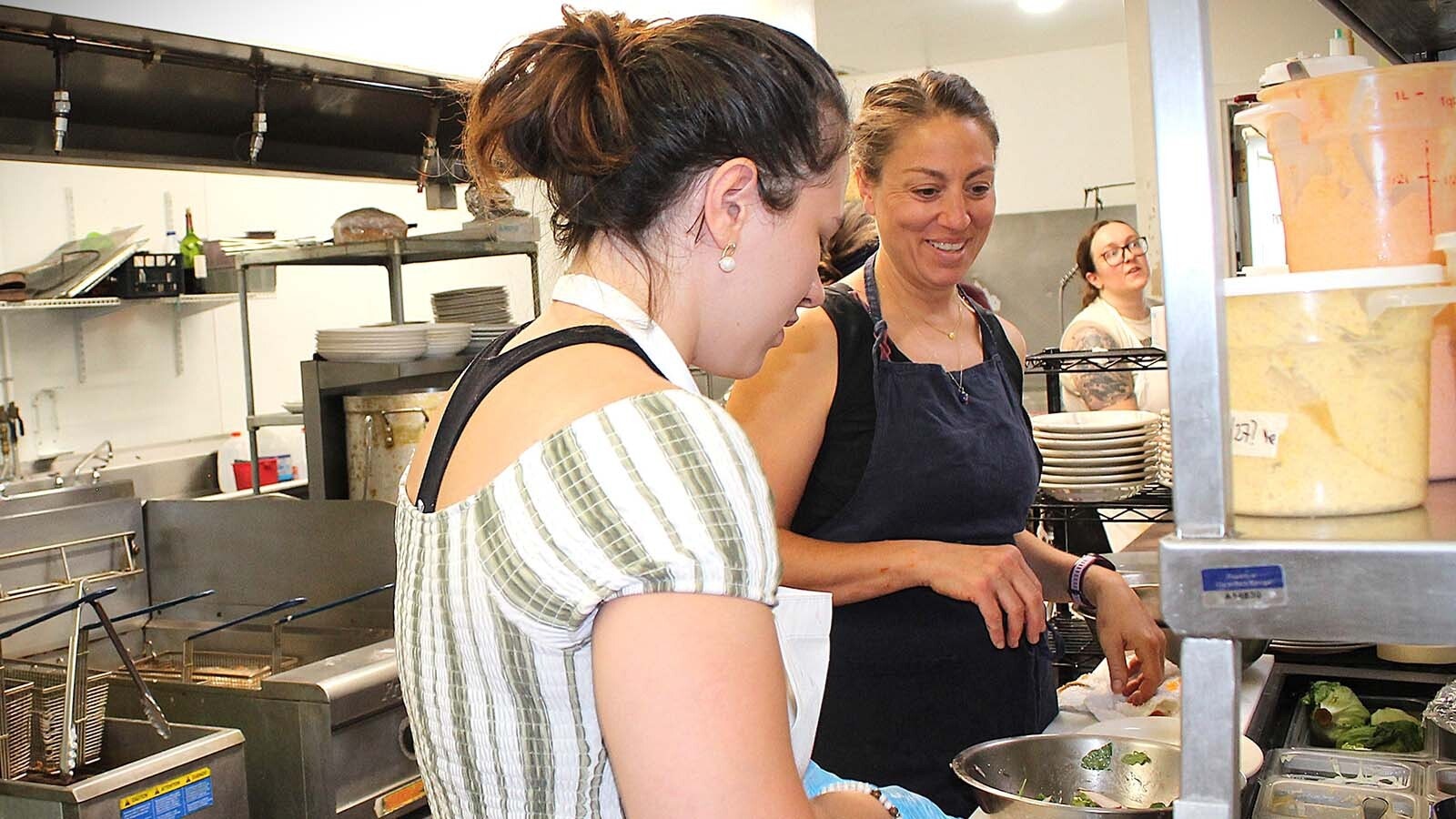 Eve Piza, right, consults with a coworker in the kitchen at her restaurant Eve's in Rock Springs.