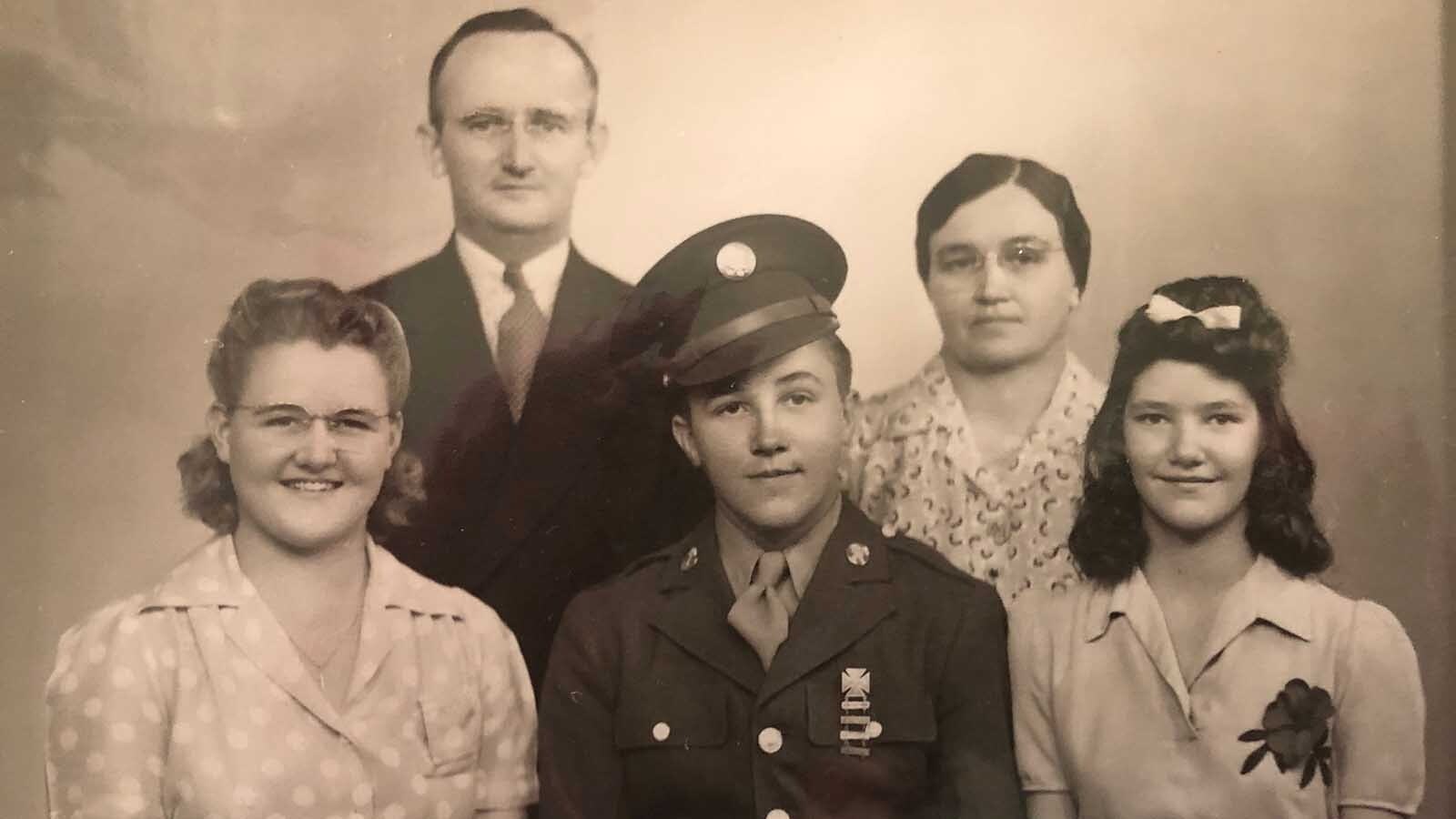 Everett Mann poses with his family for a photo as a young World War II soldier.