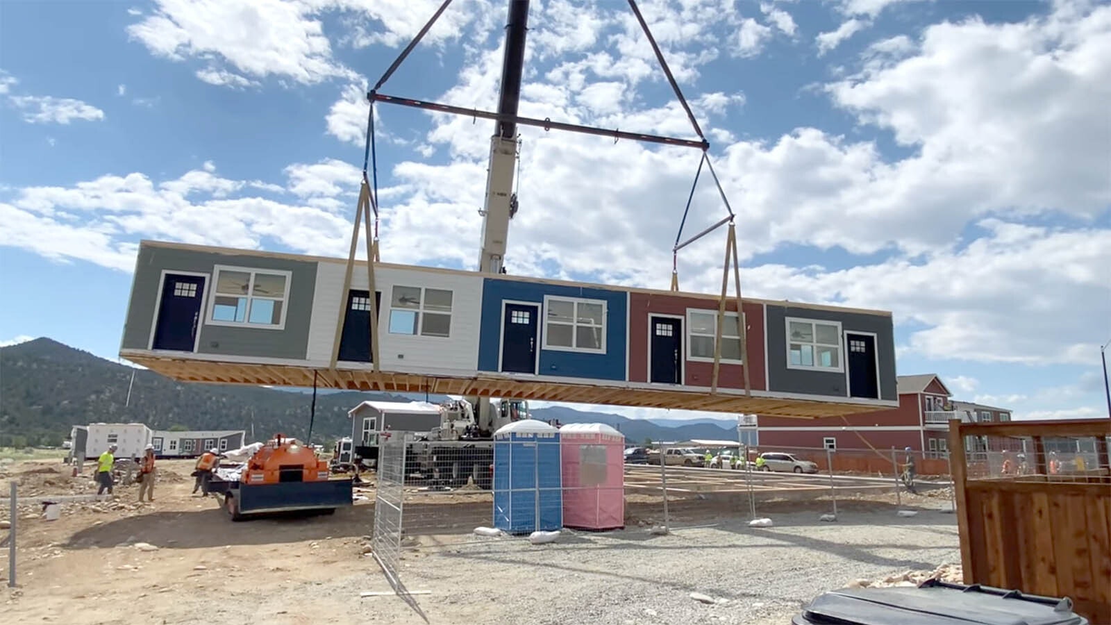 A still shot from a Fading West video showing a modular housing unit being placed on a pad.