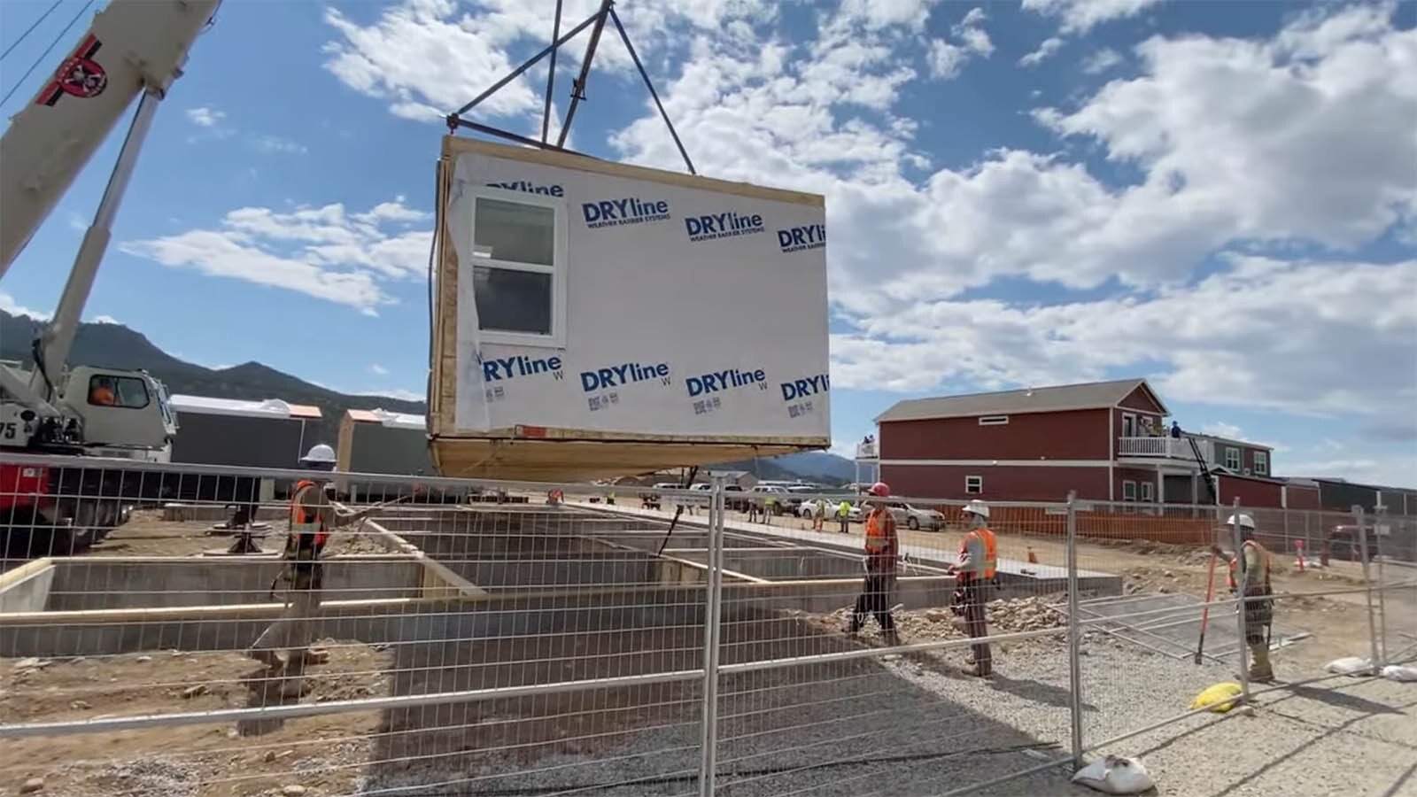 A still shot from a Fading West video showing a modular housing unit being placed on a pad.