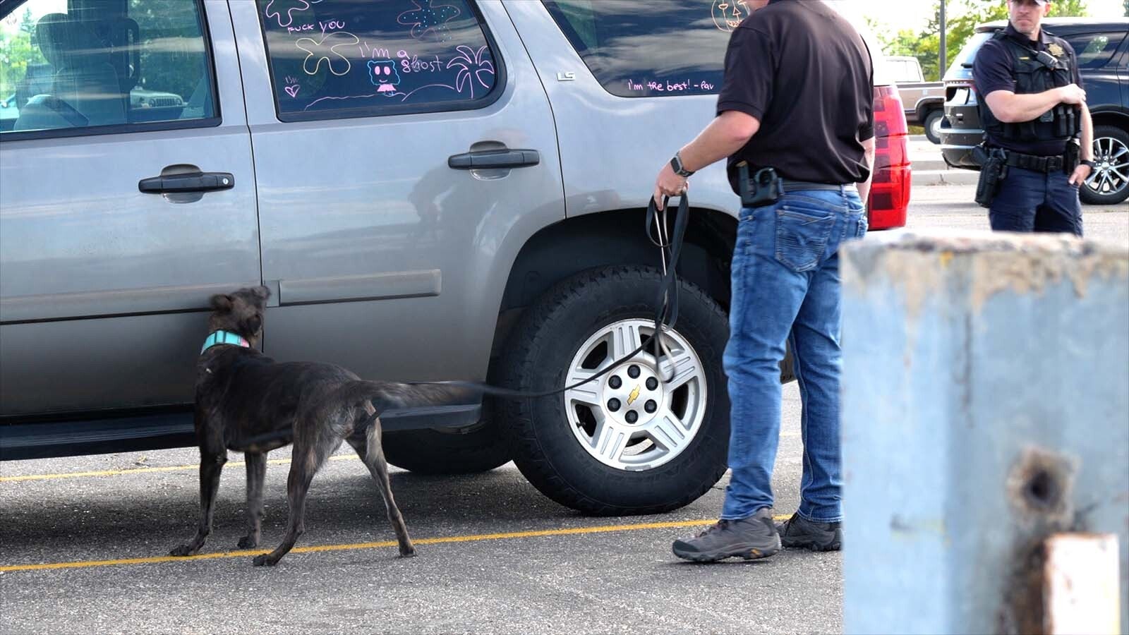 Cheyenne Police Department officers and a Laramie County Sheriff's Office deputy — and K-9 Blair — give the dog a sniff around a Chevy Tahoe in the parking lot at East High School on Thursday, Sept. 26, 2024.