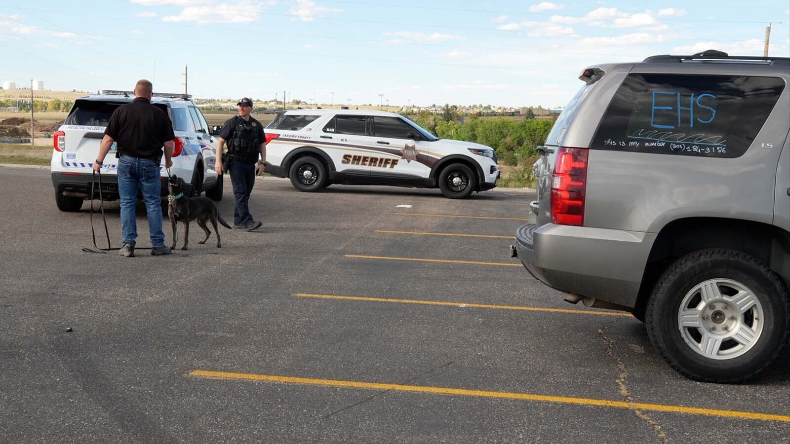 Cheyenne Police Department officers and a Laramie County Sheriff's Office deputy — and K-9 Blair — give the dog a sniff around a Chevy Tahoe in the parking lot at East High School on Thursday, Sept. 26, 2024.