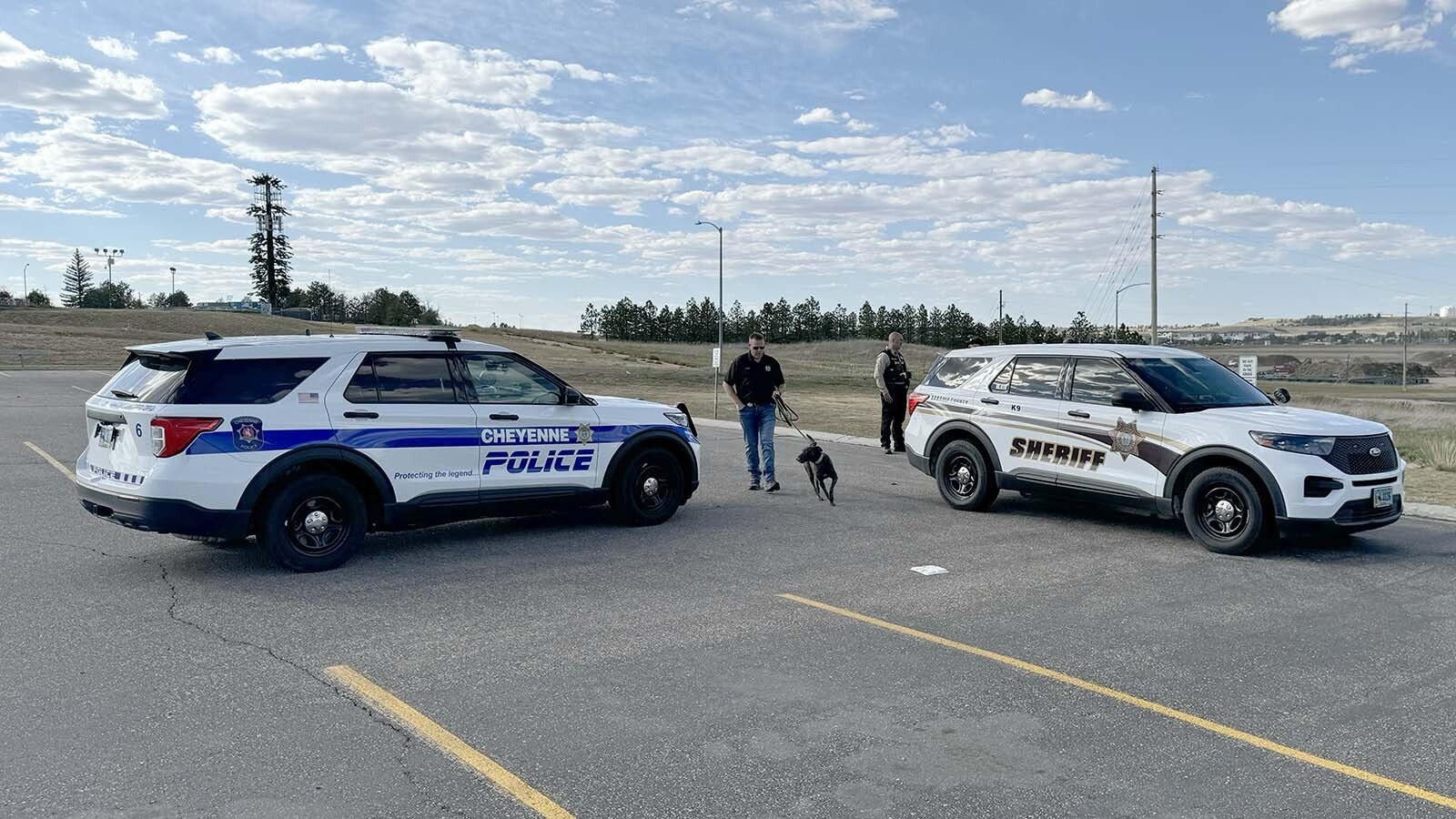 Cheyenne Police Department officers and a Laramie County Sheriff's Office deputy — and K-9 Blair — give the dog a sniff around a Chevy Tahoe in the parking lot at East High School on Thursday, Sept. 26, 2024.