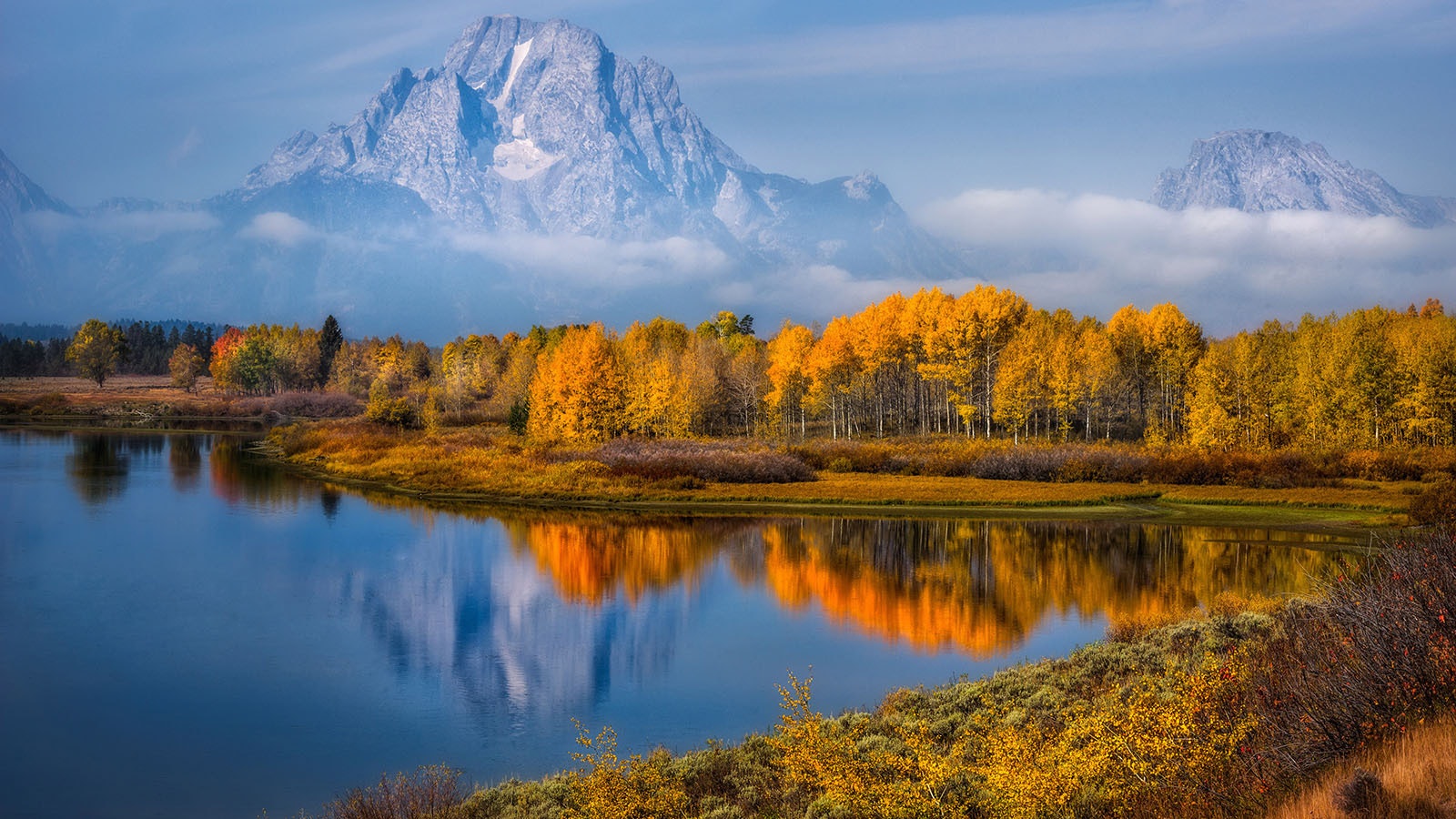 Fall colors and Mount Moran are reflected at Oxbow Bend in autumn at Grand Teton National Park in Wyoming.