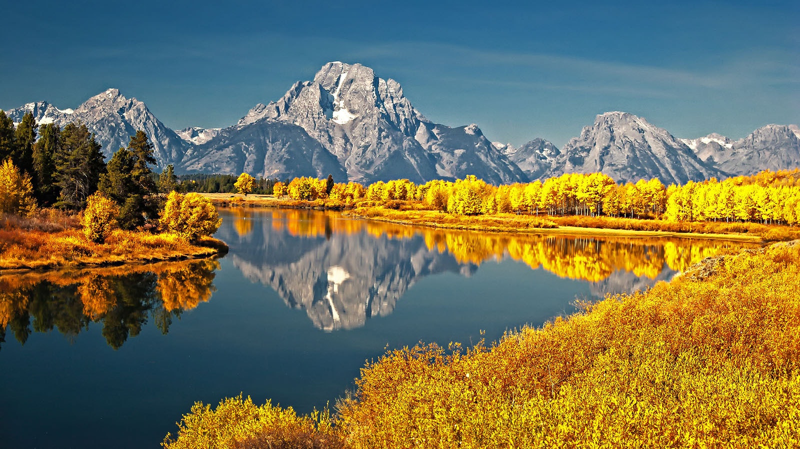 Mount Moran is reflected in Oxbow Bend in Grand Teton National Park in Wyoming, a favorite scene for photographers seeking stunning images of fall colors.