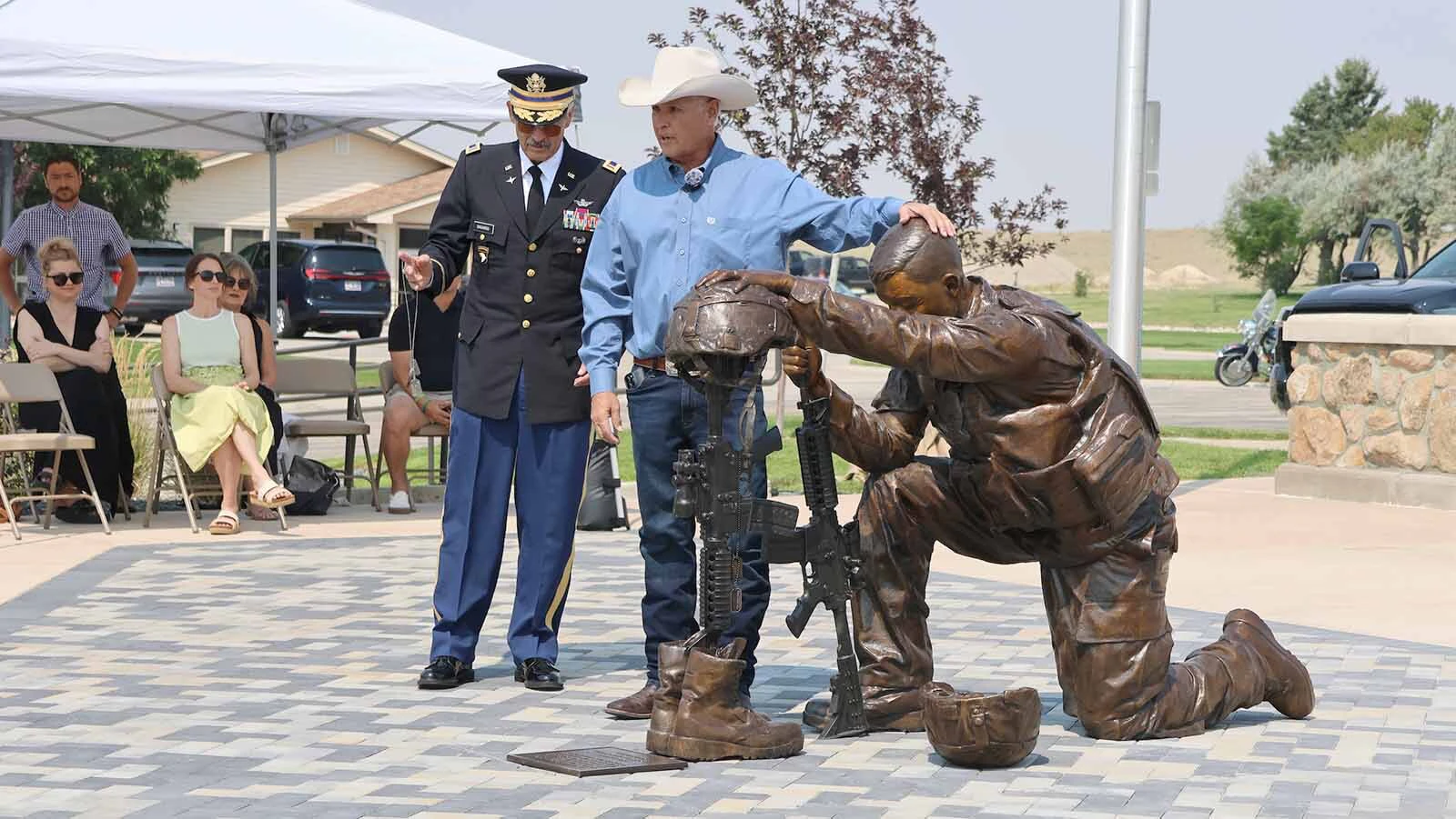 Chris Navarro explains the message on the dog tags of the sculpture, while his brother, Herb, left, prepares to add their father’s dog tags to the bronze for the day.