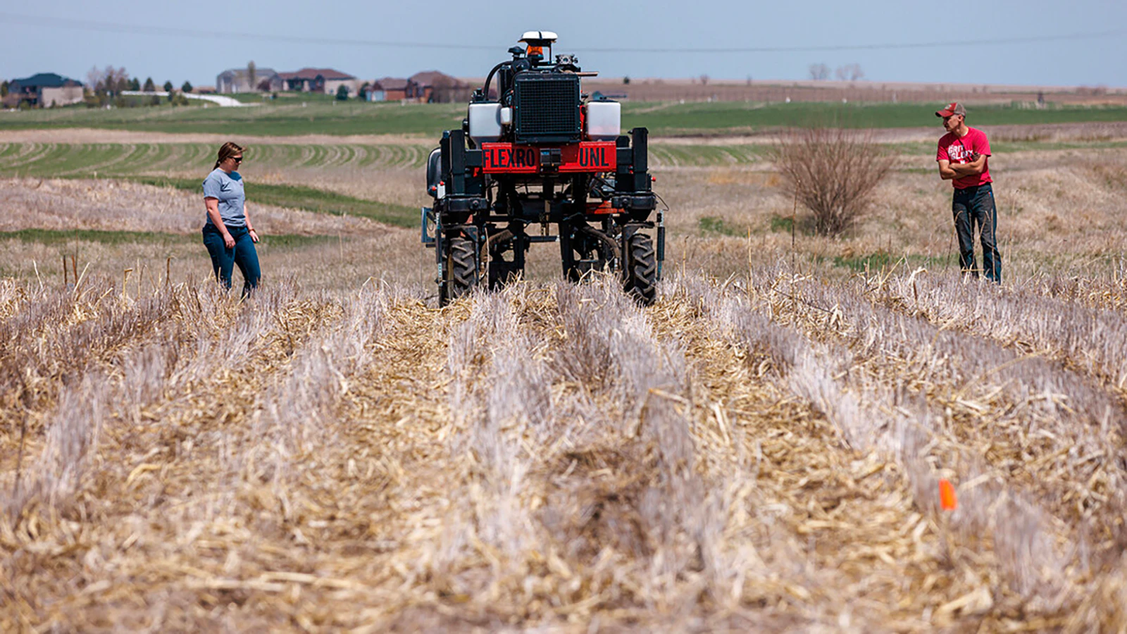 University of Nebraska graduate research assistant Taylor Cross, left, and graduate student Ian Tempelmeyer walk behind the Flex-Ro autonomous planting robot as it starts a row at Rogers Memorial Farm, east of Lincoln. Santosh Pitla, associate professor of advanced machinery systems at UN, has managed the project since the robot’s inception in 2015.