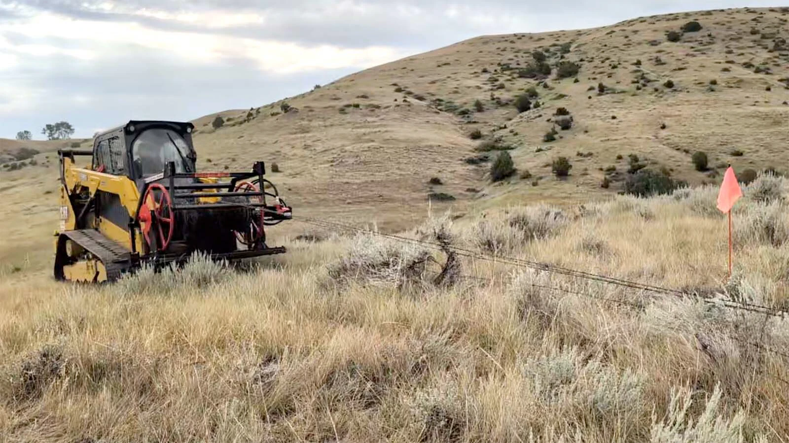 A fence winder mounted on a skid steer made short work of rolling up old wire near Sheridan. Doing the task by hand would have taken hours.