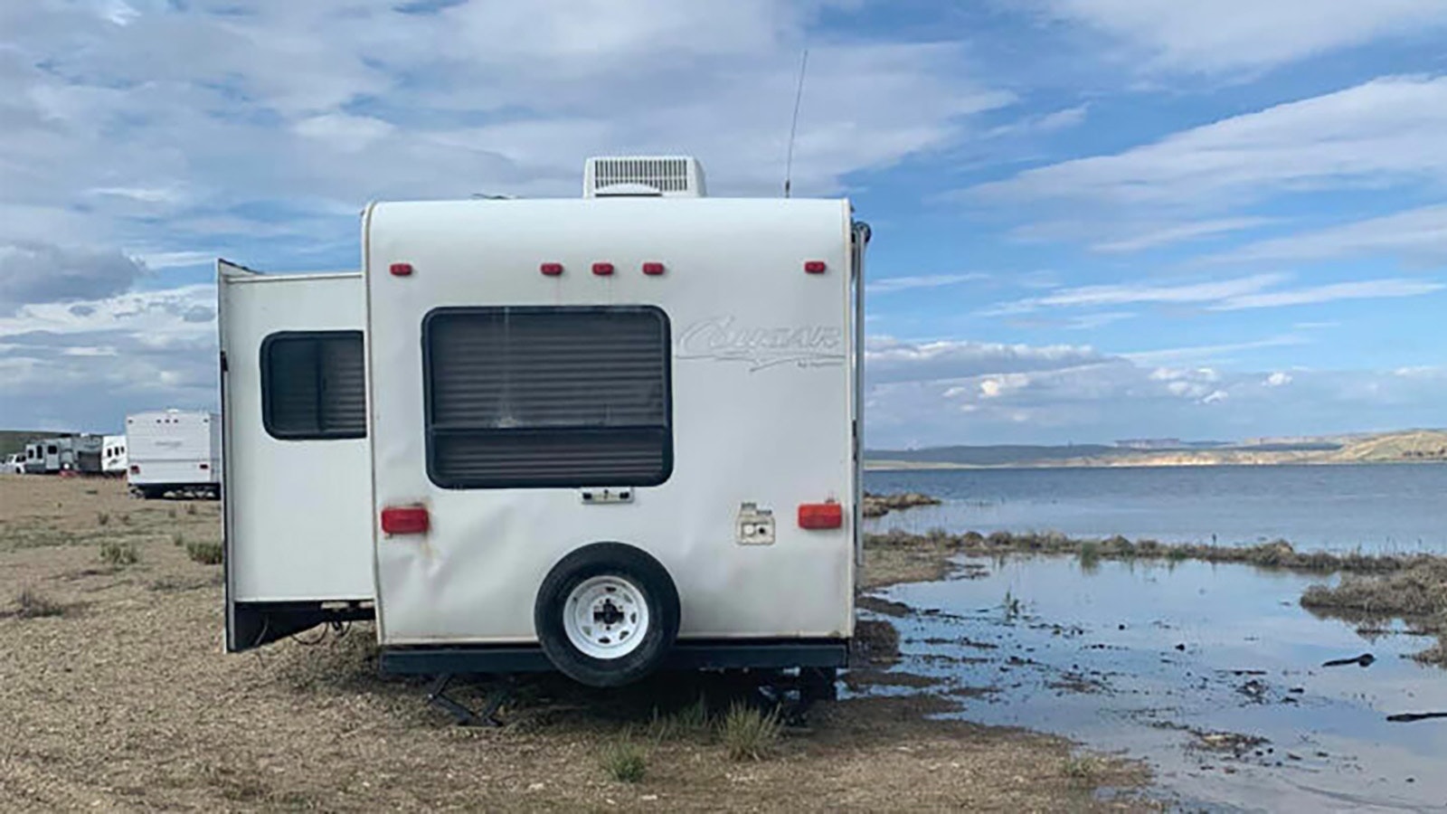 The water level rises close to a line of campers parked along the beach at Flaming Gorge Reservoir.