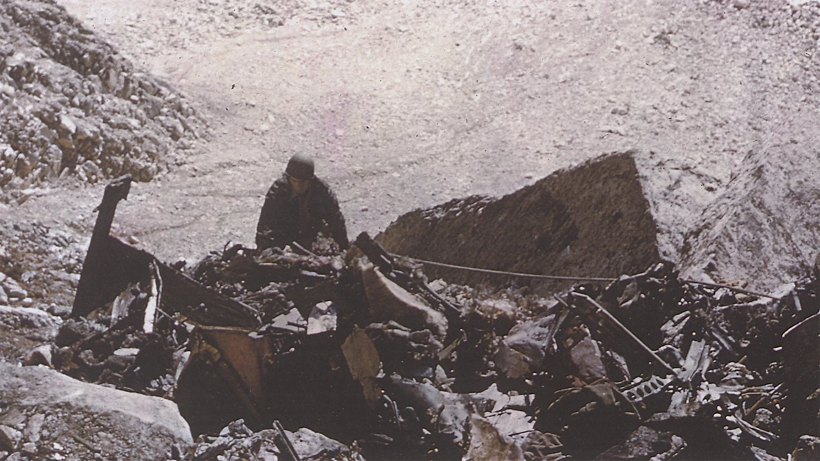 A recovery worker sifts through the crash wreckage in October 1955.