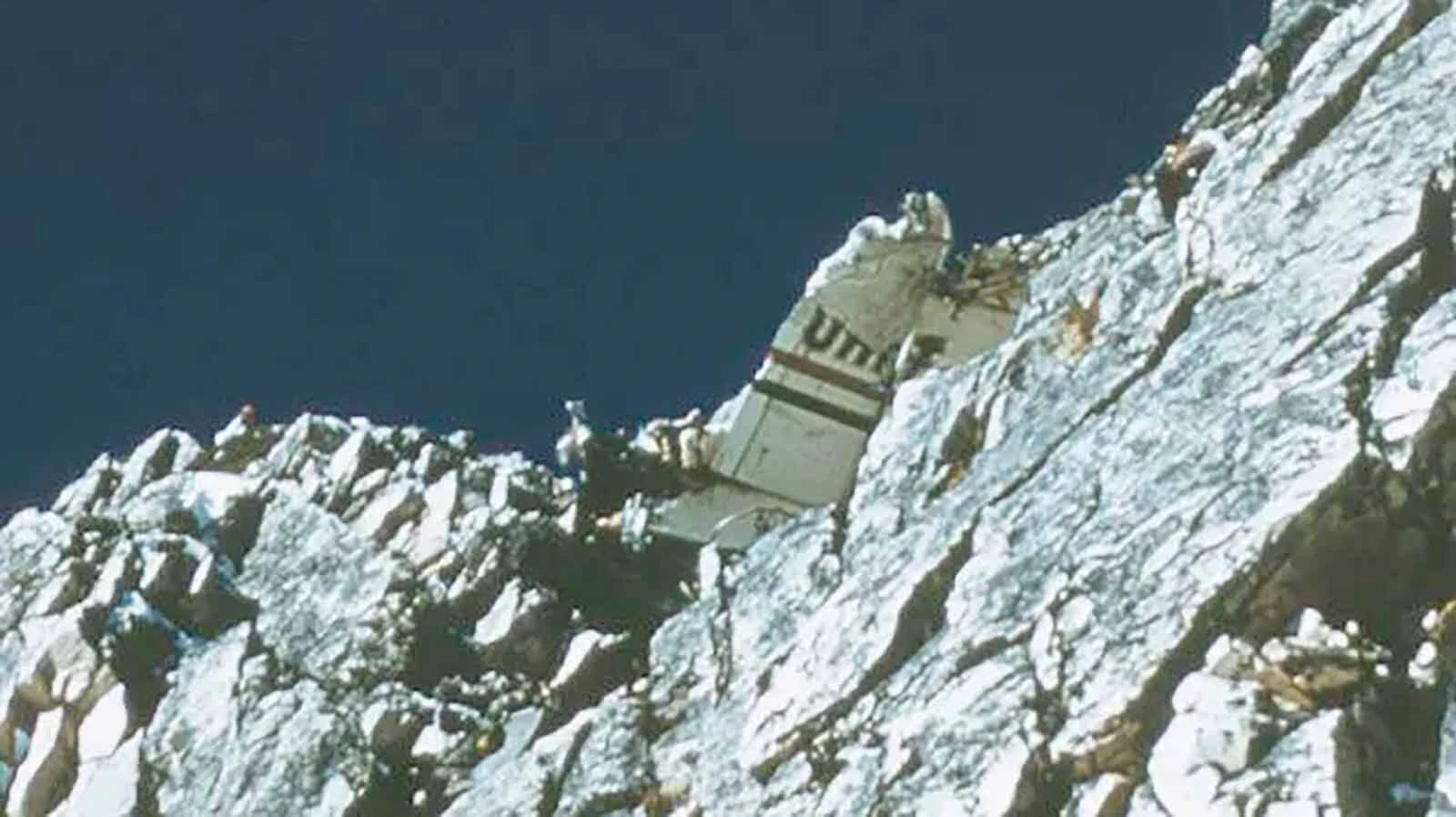 The tail section remains on the rocky mountain face.
