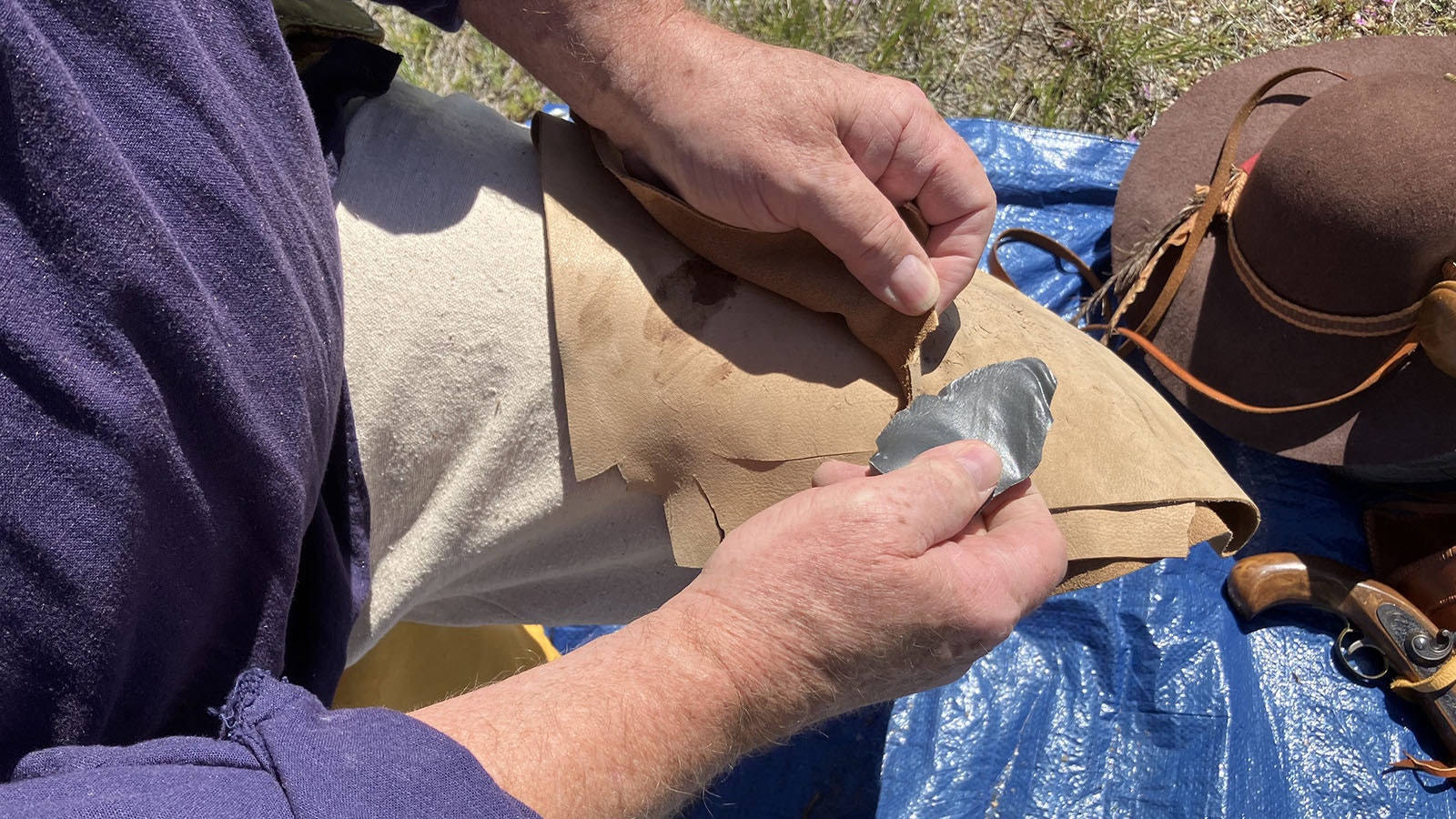 Jim Shipley demonstrates his sharp edge on a piece of leather-like material.