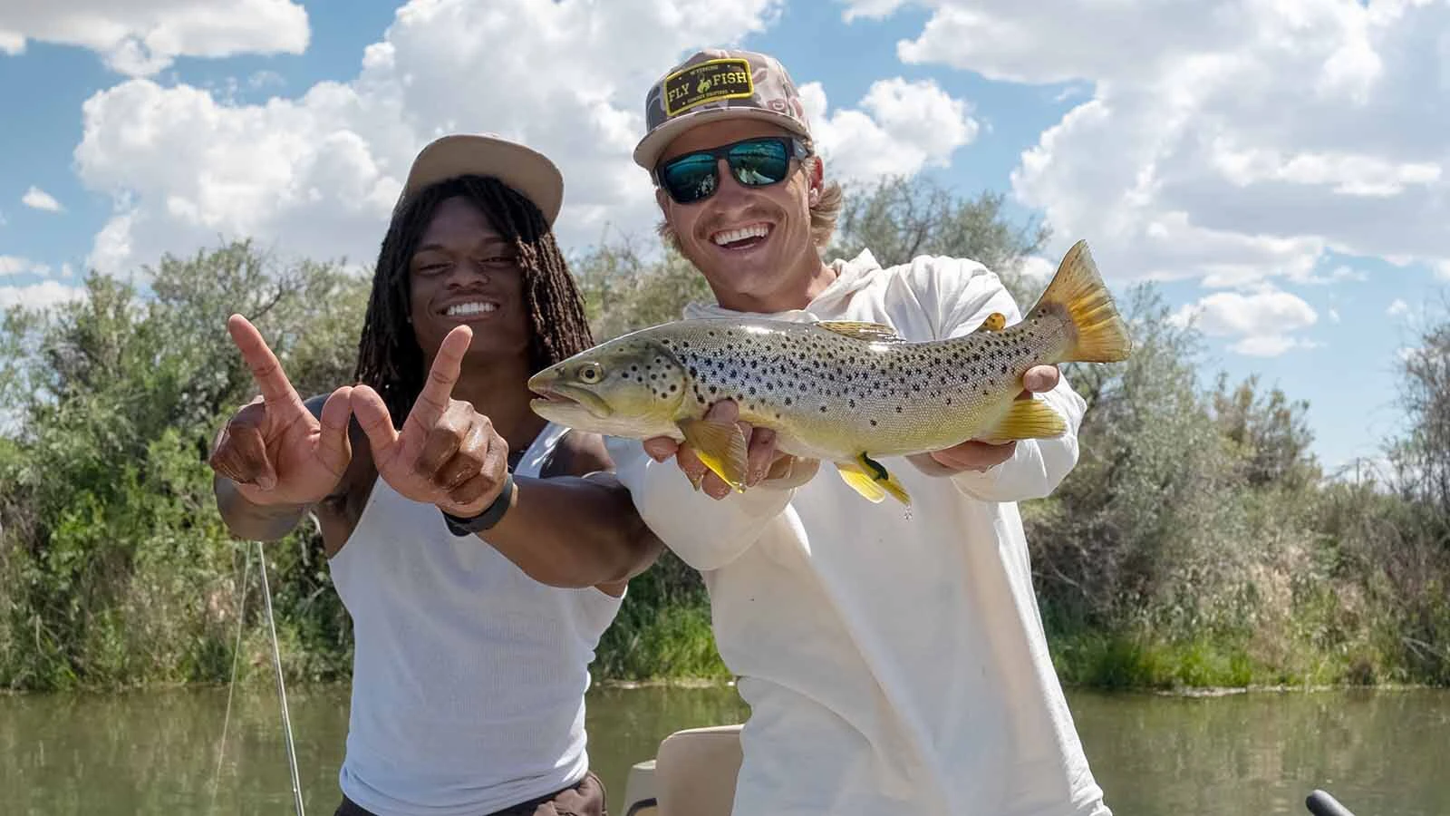 University of Wyoming  football player Tote Harris (left) and fishing guide Jarom Brown celebrate one of Harris' catches.