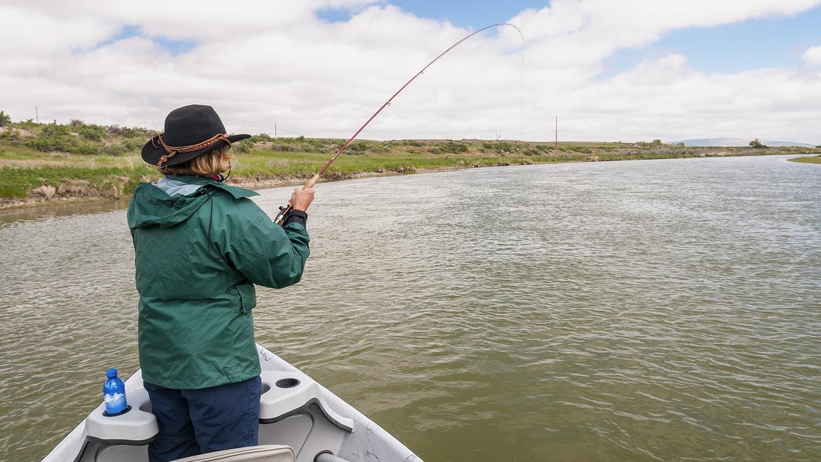 A woman fly fishes from a drift boat on the North Platte River near Casper, Wyoming.