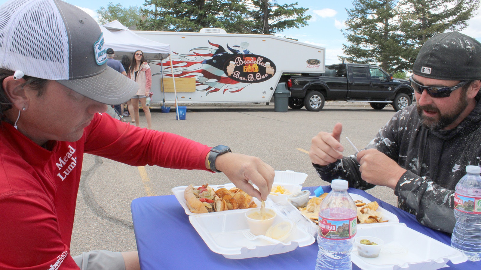 Kyle Small, right, and Joe Krause dig into some food from Casper-based WyoPhilly Wagon food truck in Downtown Cheyenne on Friday.