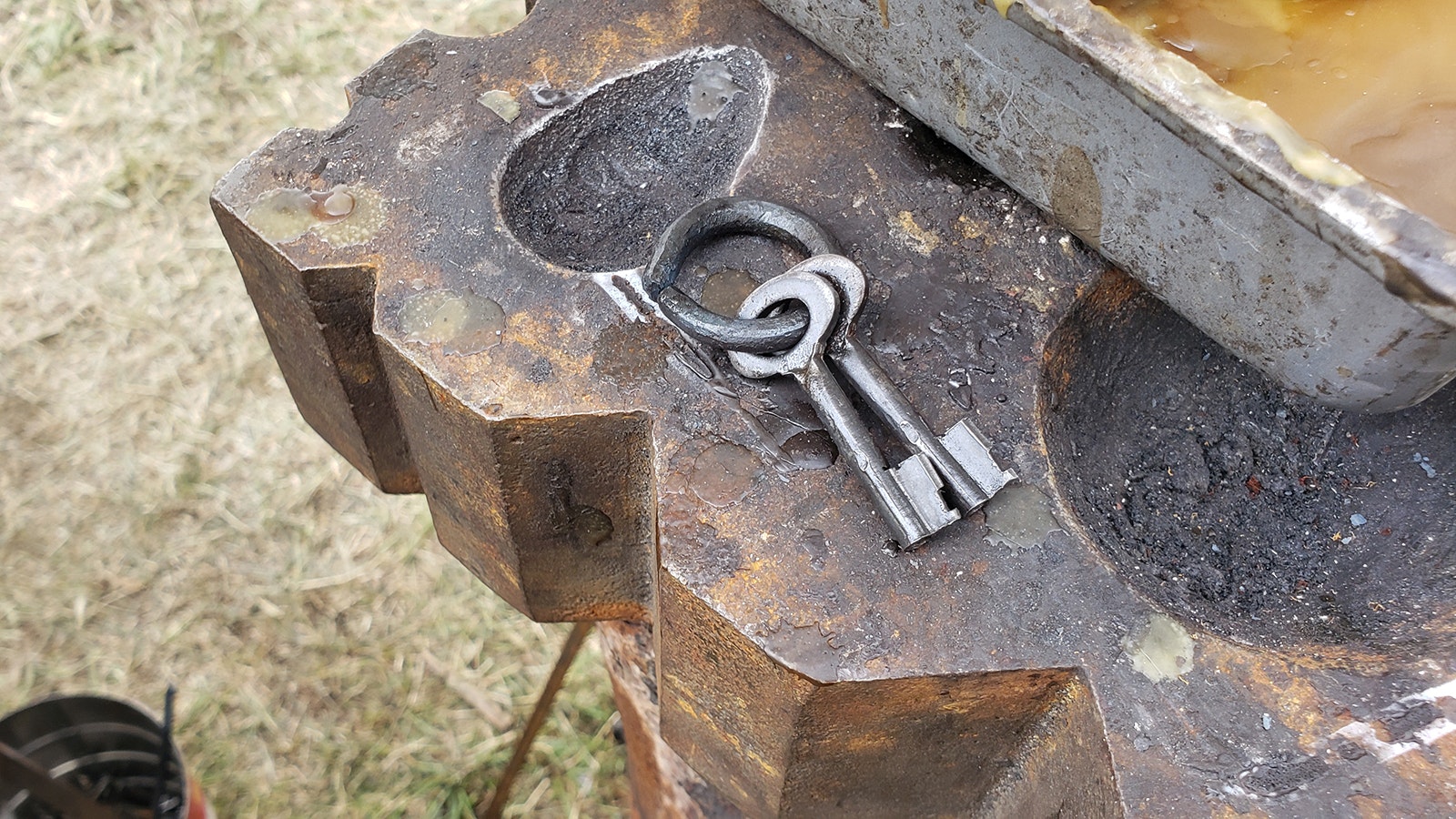 A pair of keys for an old padlock on a period correct key ring. The ring is no longer glowing, but still too hot to touch.