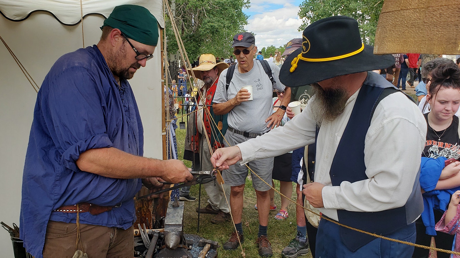 Jim Hamilton drops a couple of keys between the glowing hot ends of a new key ring being made for him by blacksmith Jesse Colton at the Fort Bridger Rendezvous.