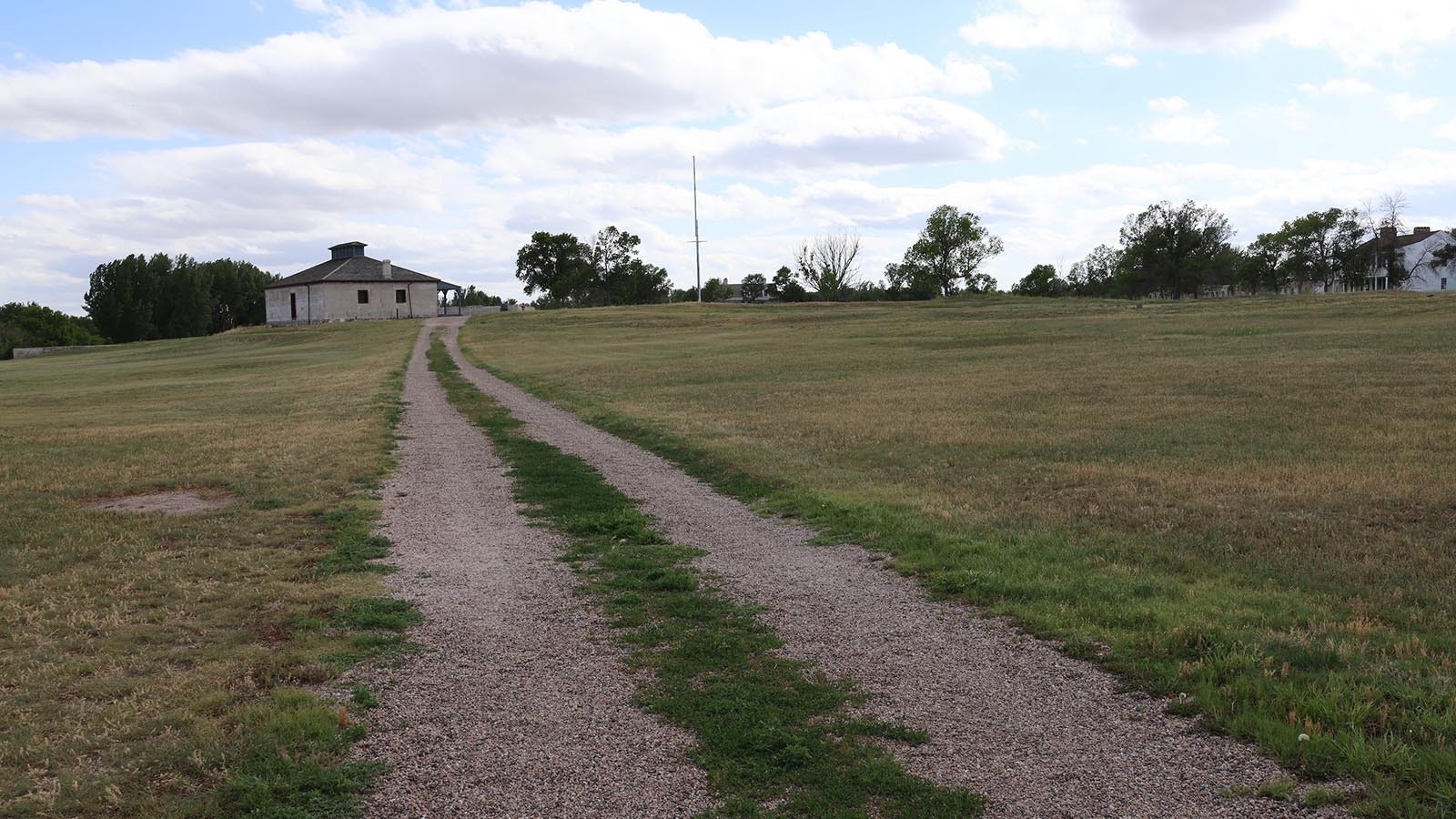 A two track in the center of Fort Laramie grounds leads up to the third and final brig building at the fort complex. The road passes by the foundations of several structures. At its height, the fort has 110 buildings.