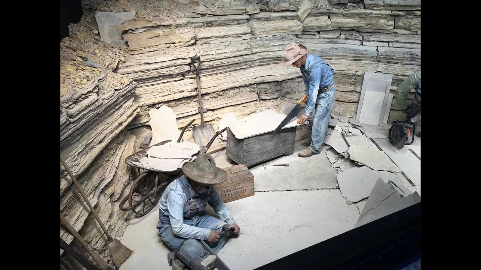 A display showing David Haddenham and another fossil miner quarrying rock containing fossils at the Fossil Butte National Monument visitor center.