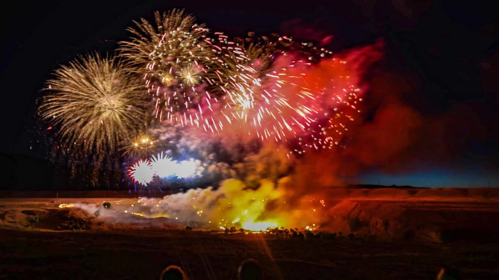 A wildfire on the northern bank of the Shoshone River during the 2026 Cody Fireworks Show. Photographer Laura Redmond said the fire started "immediately" after the first fireworks, and burned throughout and after the show, but was extinguished by the Cody Volunteer Fire Department.