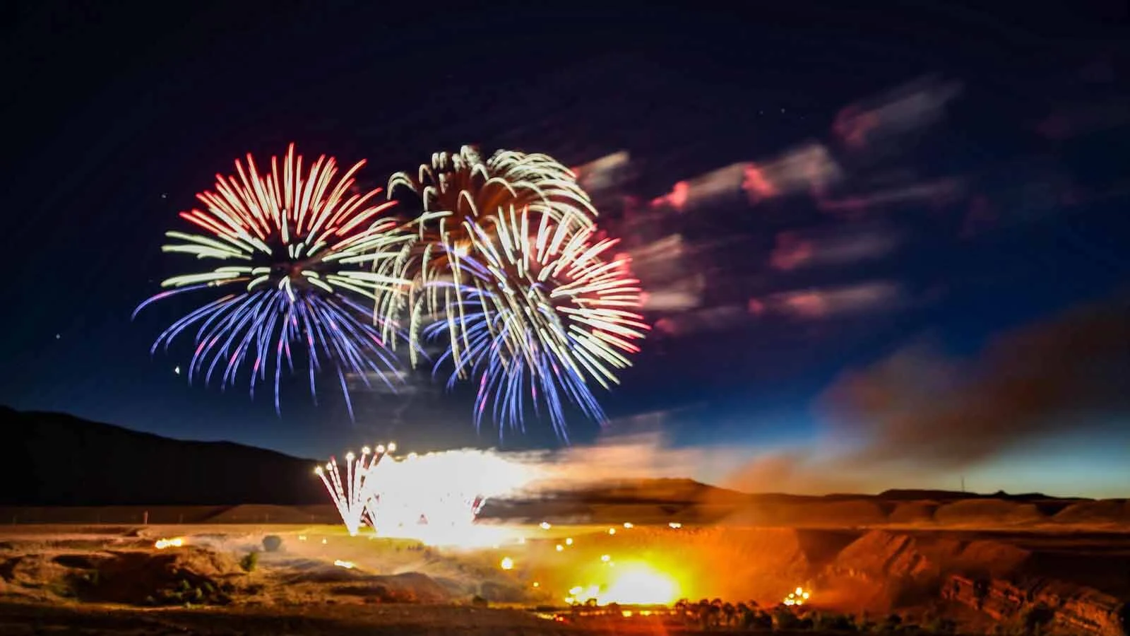 A wildfire on the northern bank of the Shoshone River during the 2026 Cody Fireworks Show. Photographer Laura Redmond said the fire started "immediately" after the first fireworks, and burned throughout and after the show, but was extinguished by the Cody Volunteer Fire Department.