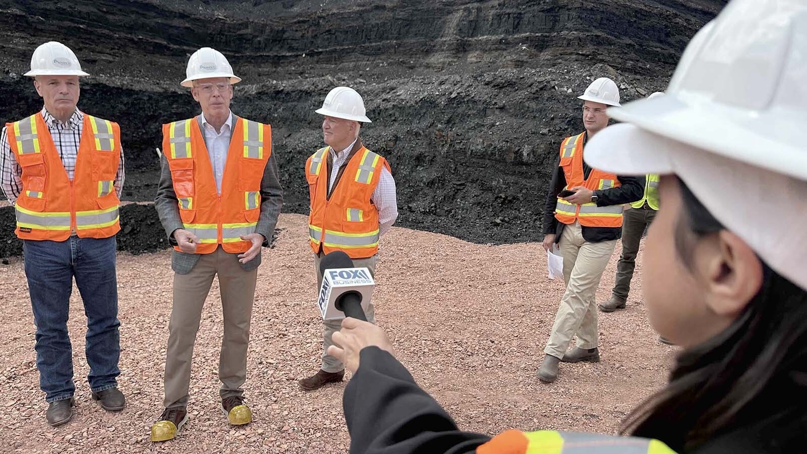 A Fox Business reporter listens with the press pool as Gov. Mark Gordon, from left, U.S. Energy Secretary Chris Wright center and Ramaco CEO Randal Atkins talk about the rare earth potential at the Brook Mine near Ranchester, Wyoming, on Friday, July 11, 2025..