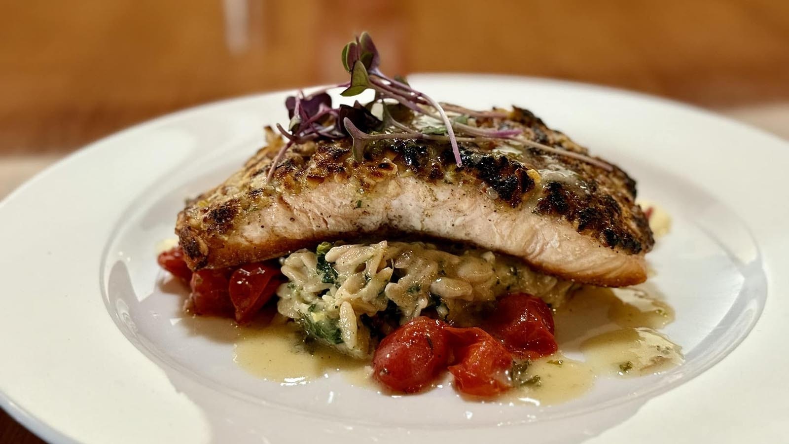 Herb crusted salmon topped with a brown butter beurre blanc served over braised green orzo.