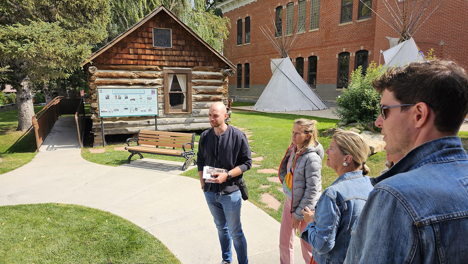 French tour directors learn about the. homestead cabin outside the Jim Gatchell Museum.