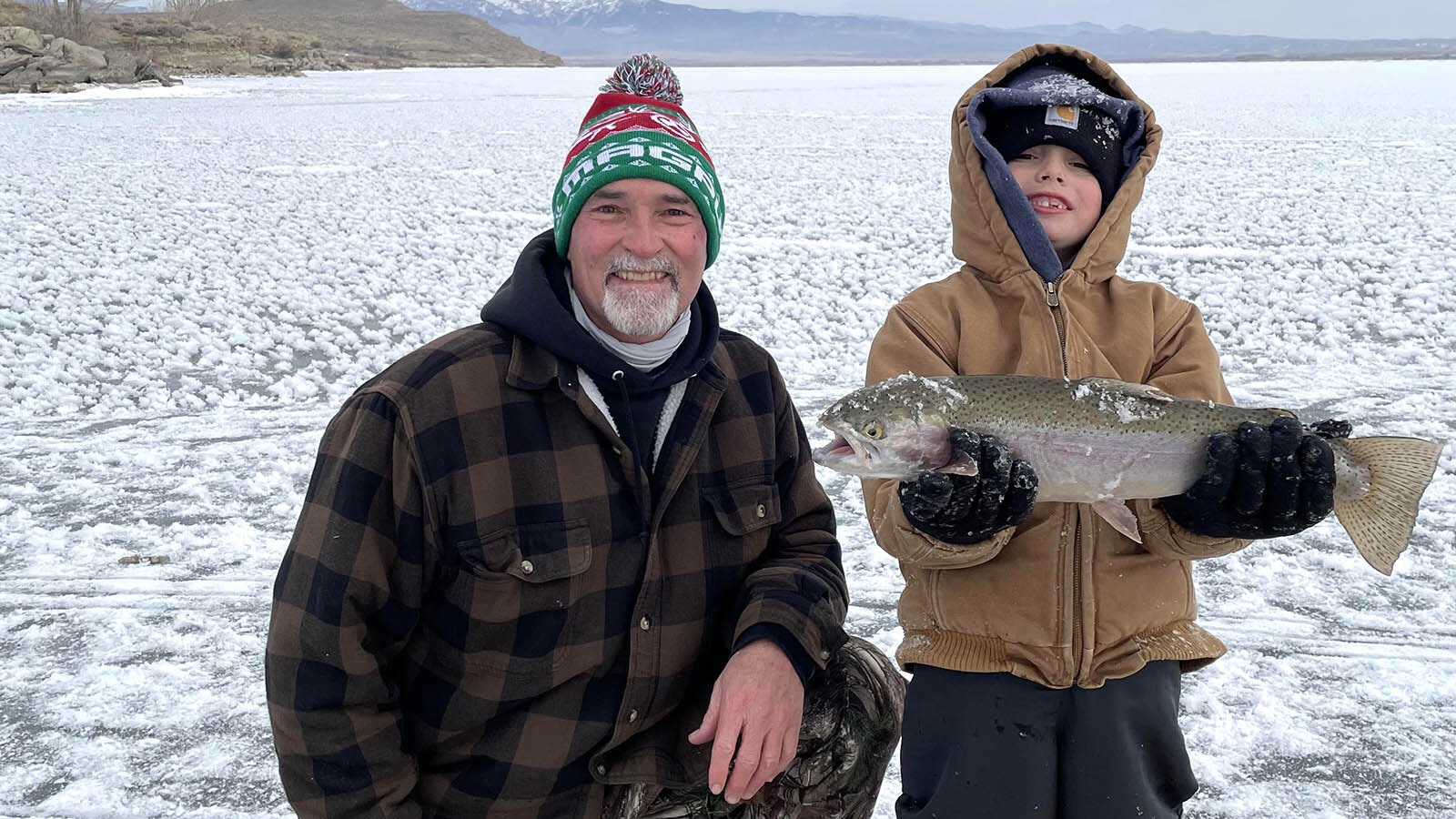 Ed Reish, left, and his grandson McCrae Puckett were all smiles catching fish through the ice on Boysen Reservoir with a field of frozen ice flowers littering the lake.
