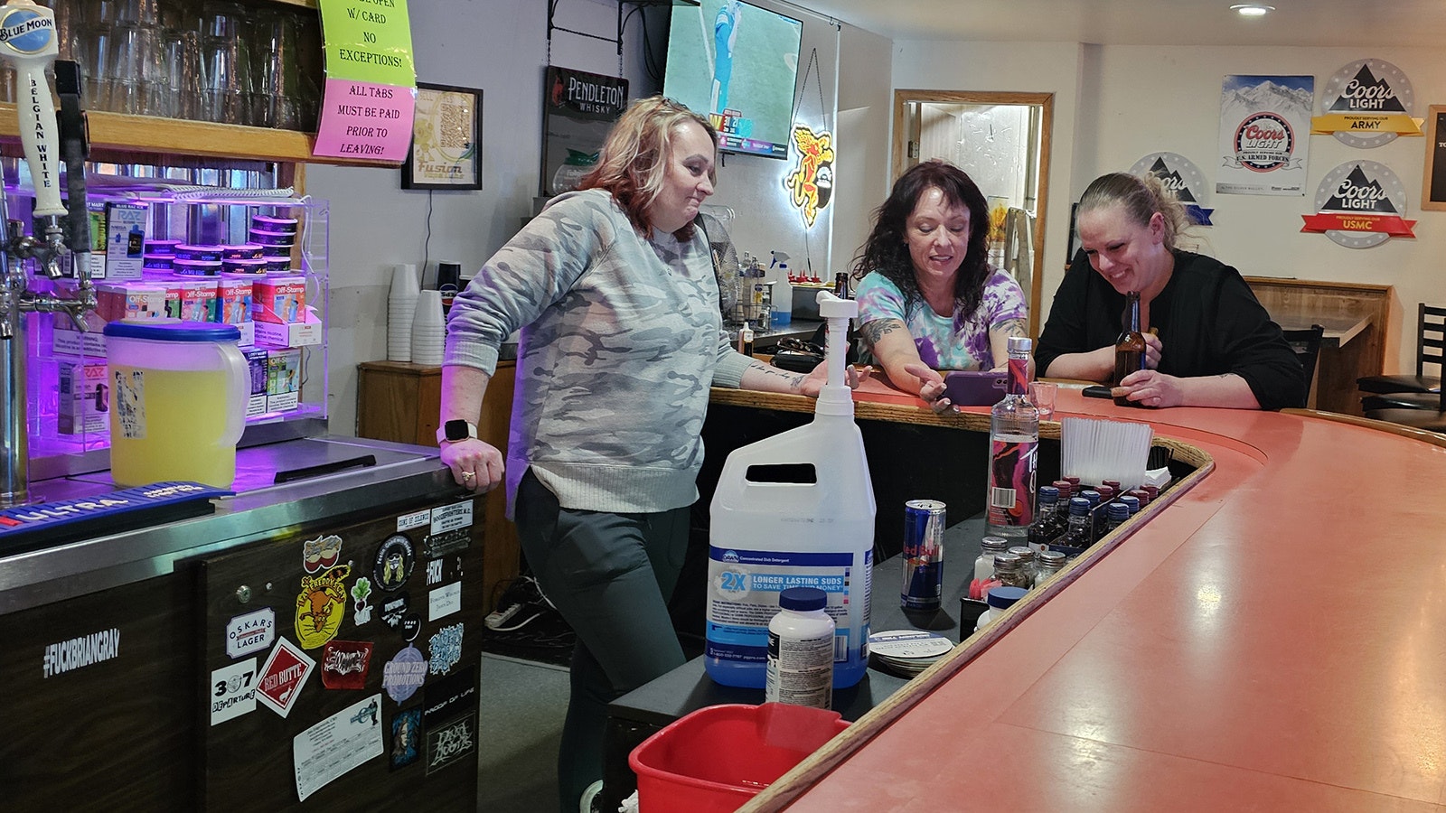 Stacey Quick watches a video on a couple of bar patrons' phone at Frosty's in Casper.