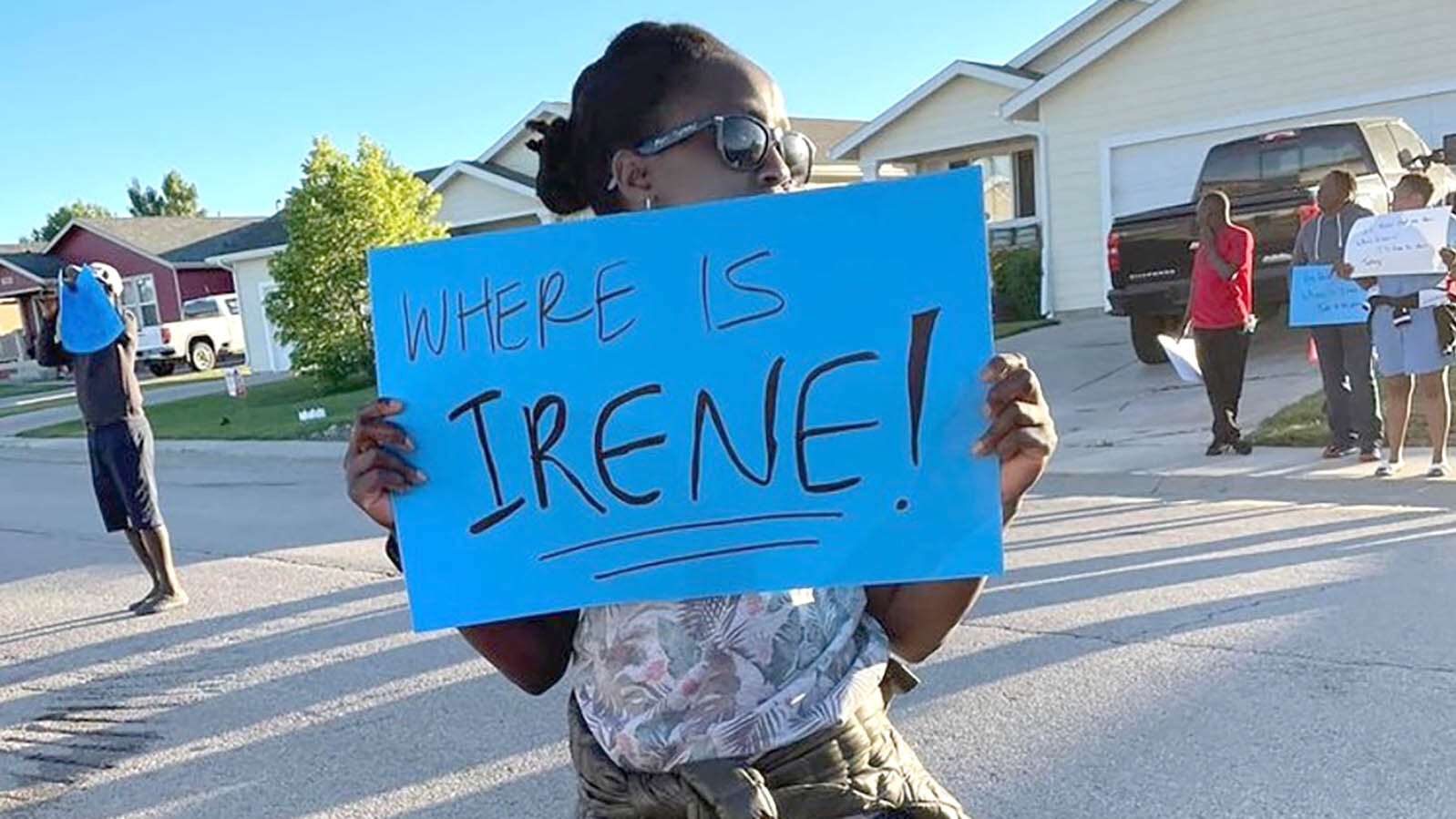 A protestor stands outside Nathan Hightman's home in Gillette in July 2022.