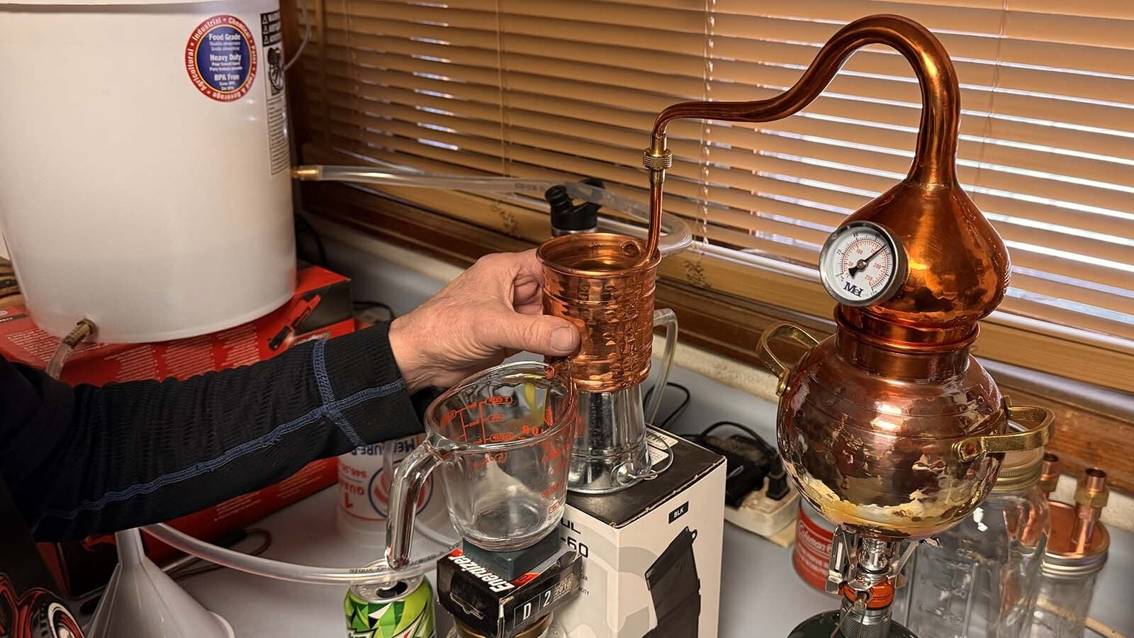 After watching the Discovery Channel show "Moonshiners," Cheyenne mechanic Geno Stecks was inspired to try it on his own. So far, his tiny hobby moonshine still has produced about 1.5 cups of hooch since December. At that rate, he thinks it'll take "about a year" to fill one of his tiny 2-liter oak kegs.