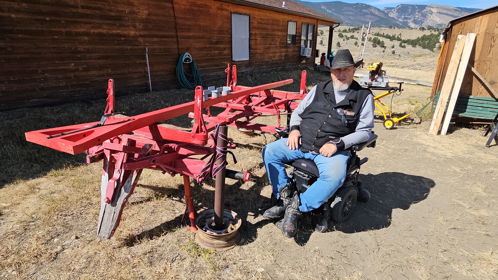 George Clark by one of the running gears he's restoring for a sheep wagon.