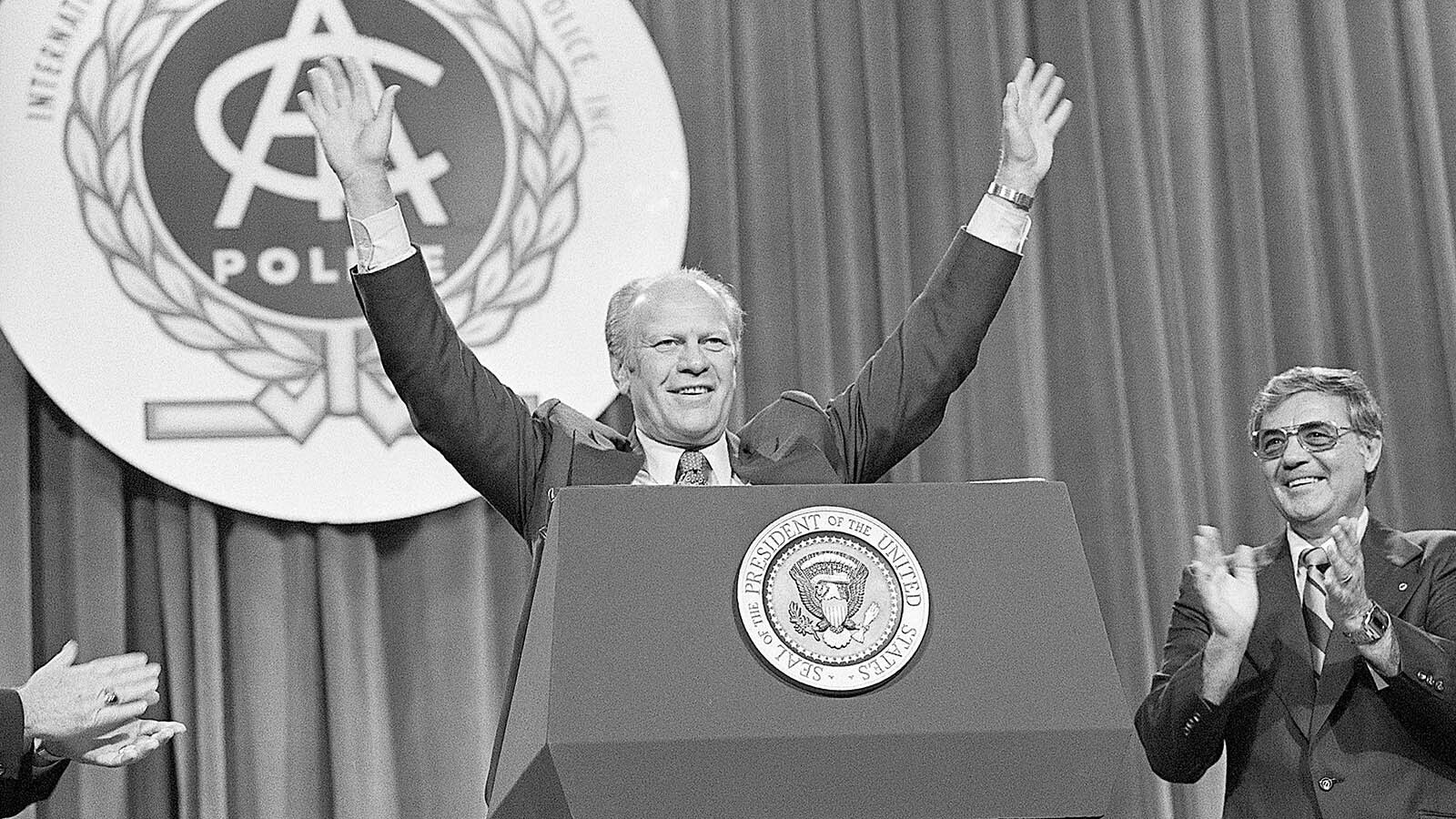 President Ford smiles as he acknowledges the reception given to him at the convention of the International Association of Chiefs of Police on Sept. 27, 1976, in Miami Beach, Fla. Ford said if elected in November the first 100 days of his term will be spent rallying Americans in a battle against crime.