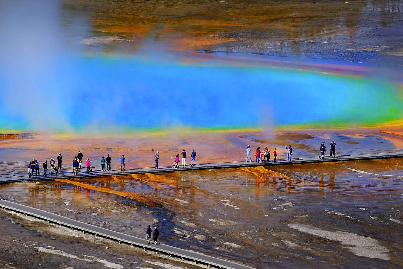 Visitors walk along the boardwalk at Grand Prismatic Spring in Yellowstone National Park, which has opened for the 2024 tourism season.