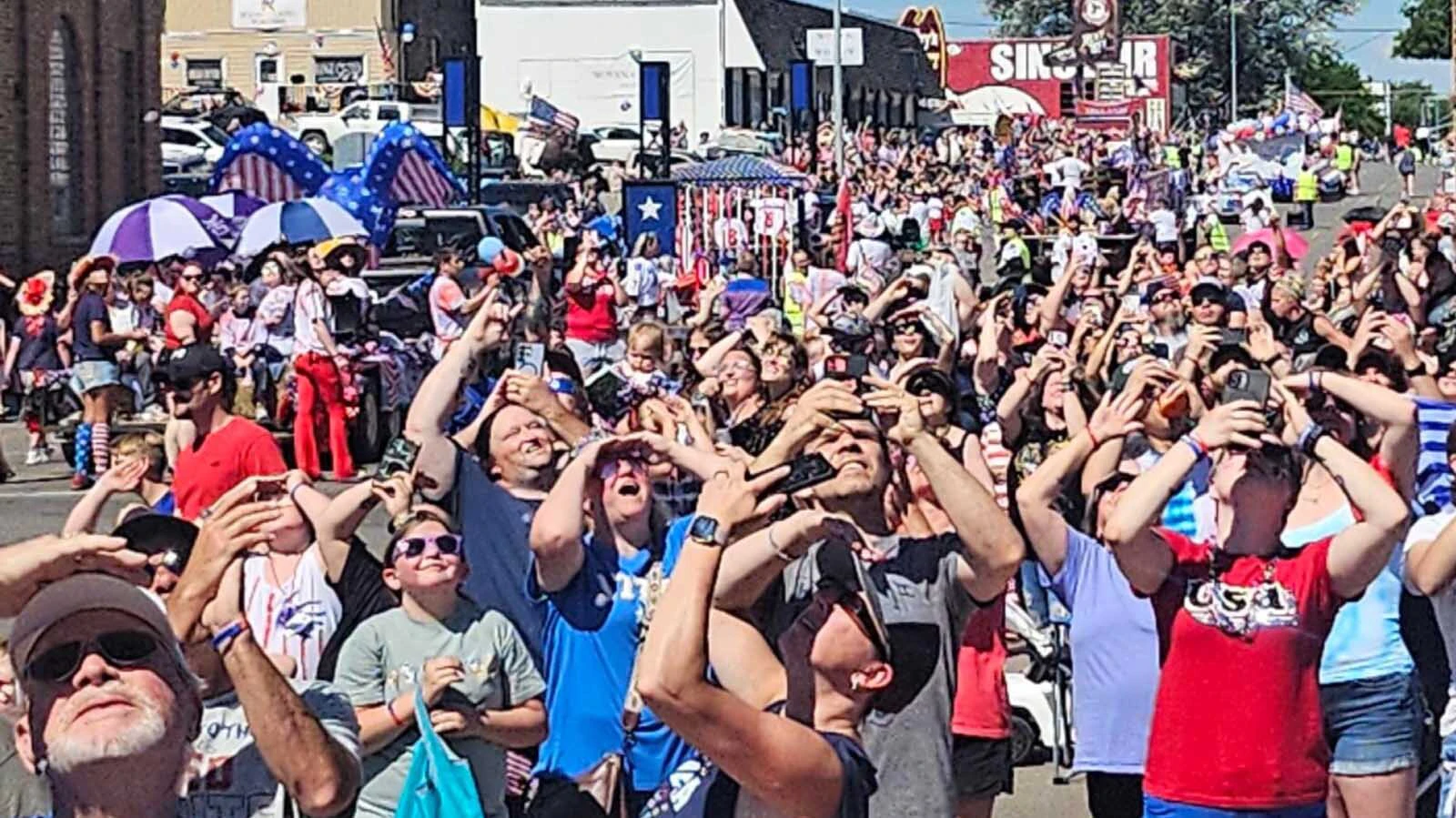 Fourth of July parade-goers in Gillette watch a flyover.