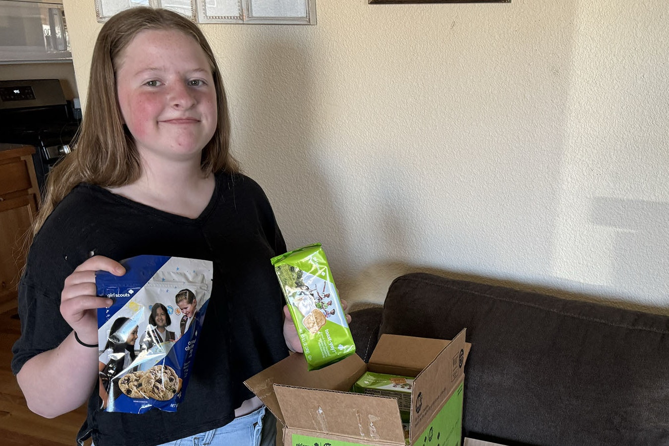 Emma McCarroll, a 13-year-old Girl Scout, shows off some of the remaining Girl Scout Cookies that she has left to sell. She’s hawked nearly 1,200 boxes so far, good enough to pay her way to summer camp in Montana.