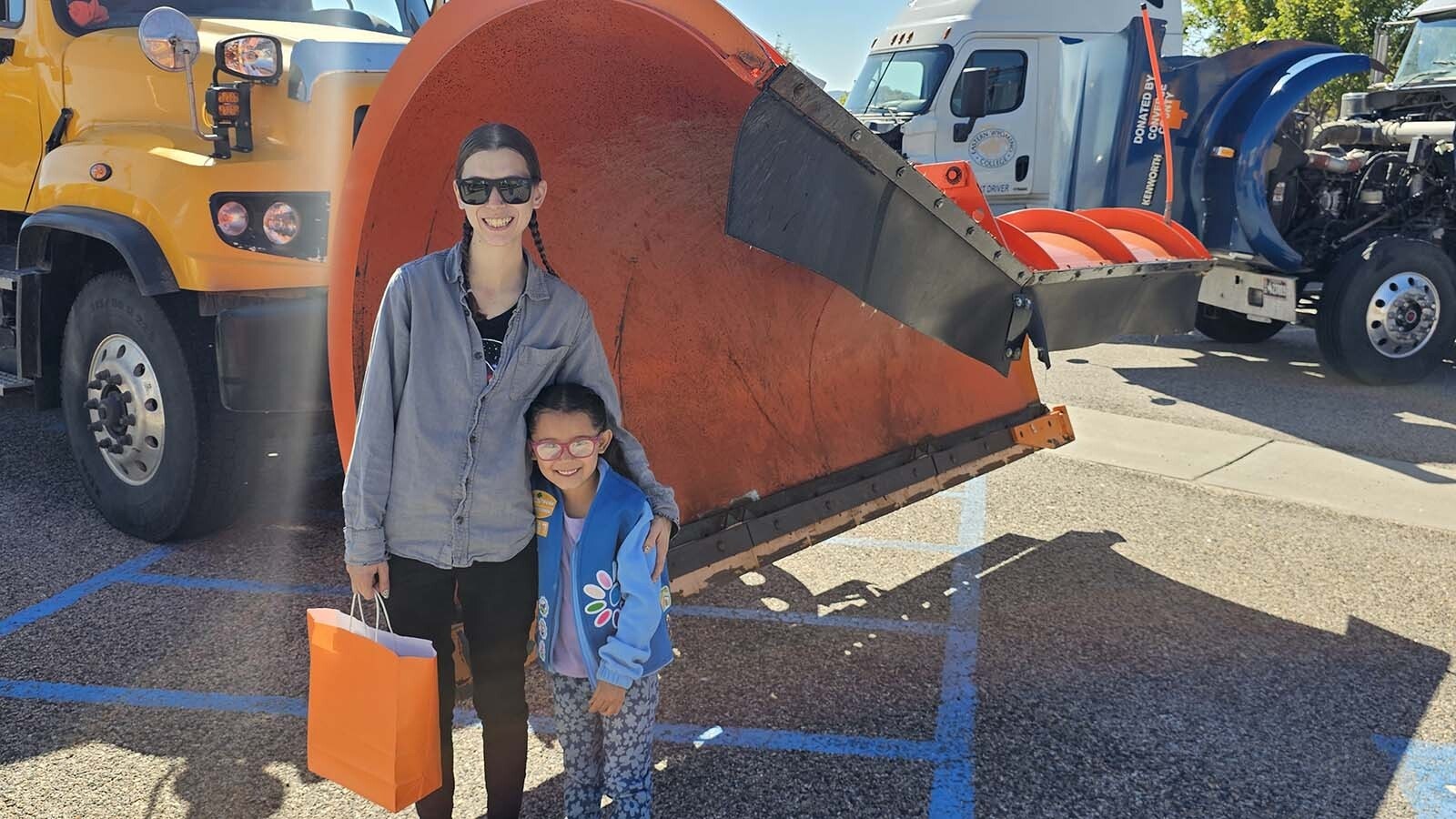 Jordan Ambrose poses with her daughter Octavia Ambrose in front of one of the Wyoming Department of Transportation's snowplow trucks  during the annual Trucks Are For Girls Event, held every fall, at Eastern Wyoming College's Douglas campus..