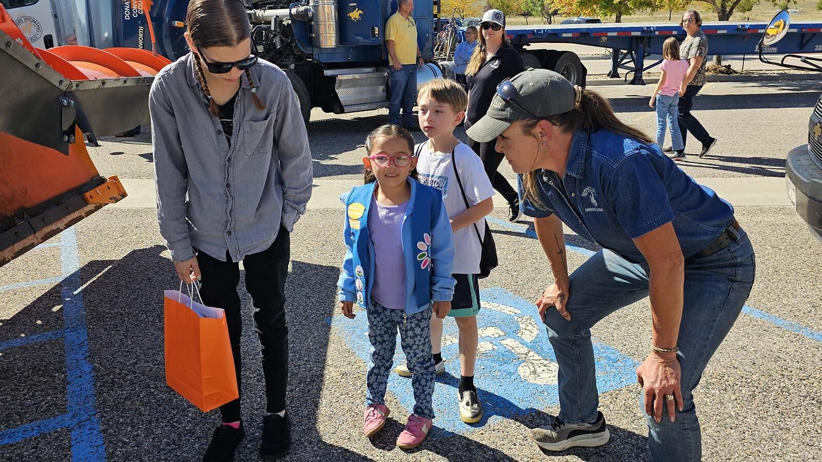 WYDOT CDL Supervisor Erin King, right, answers Octavia Butler's questions about trucks, while mom, Jordan Butler, left) listens during the annual Trucks Are For Girls Event, held every fall, at Eastern Wyoming College's Douglas campus.