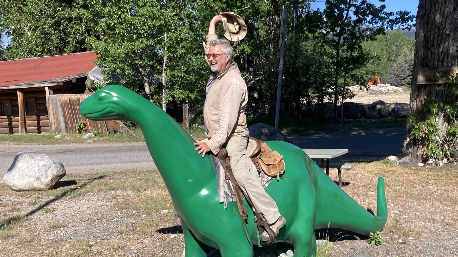 Glenn Storrs rides a saddle-up dinosaur at a Sinclair station in Wyoming.