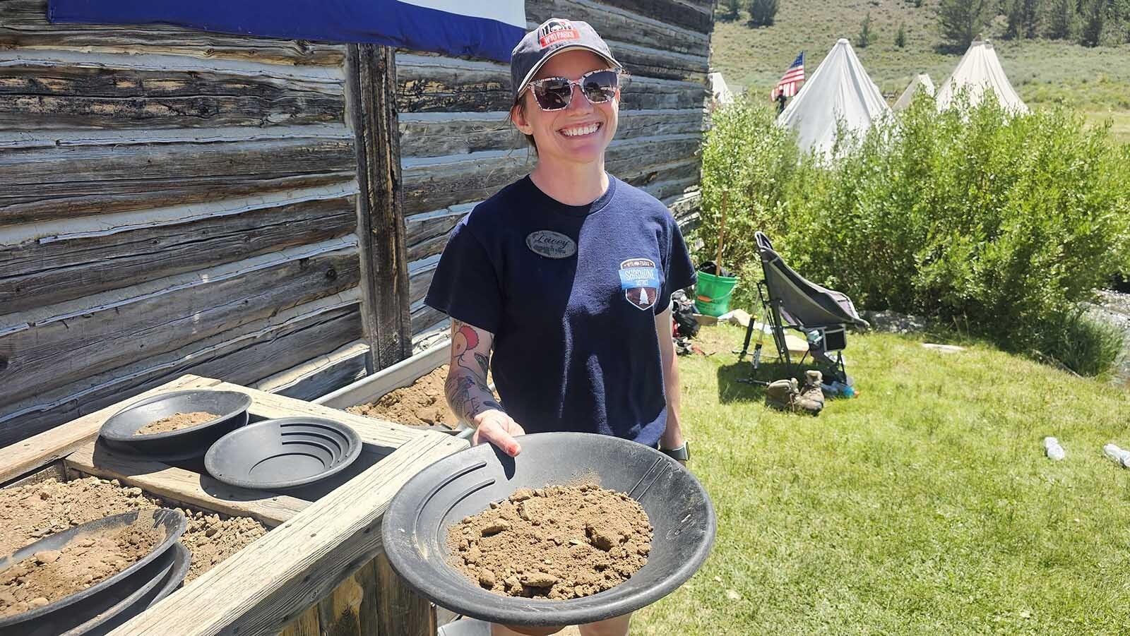 A volunteer hands over a pan of pay dirt during Gold Rush Days at South Pass City.